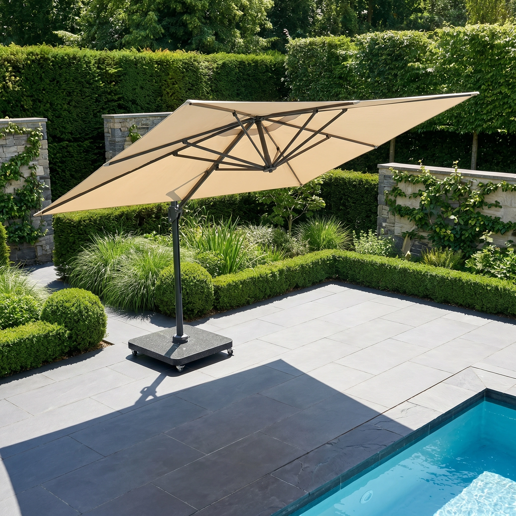 The Challenger T2 Premium 3.5m x 2.6m Rectangular Cantilever Parasol in Champagne offers stylish shade beside a modern pool, bordered by green hedges and stone walls.
