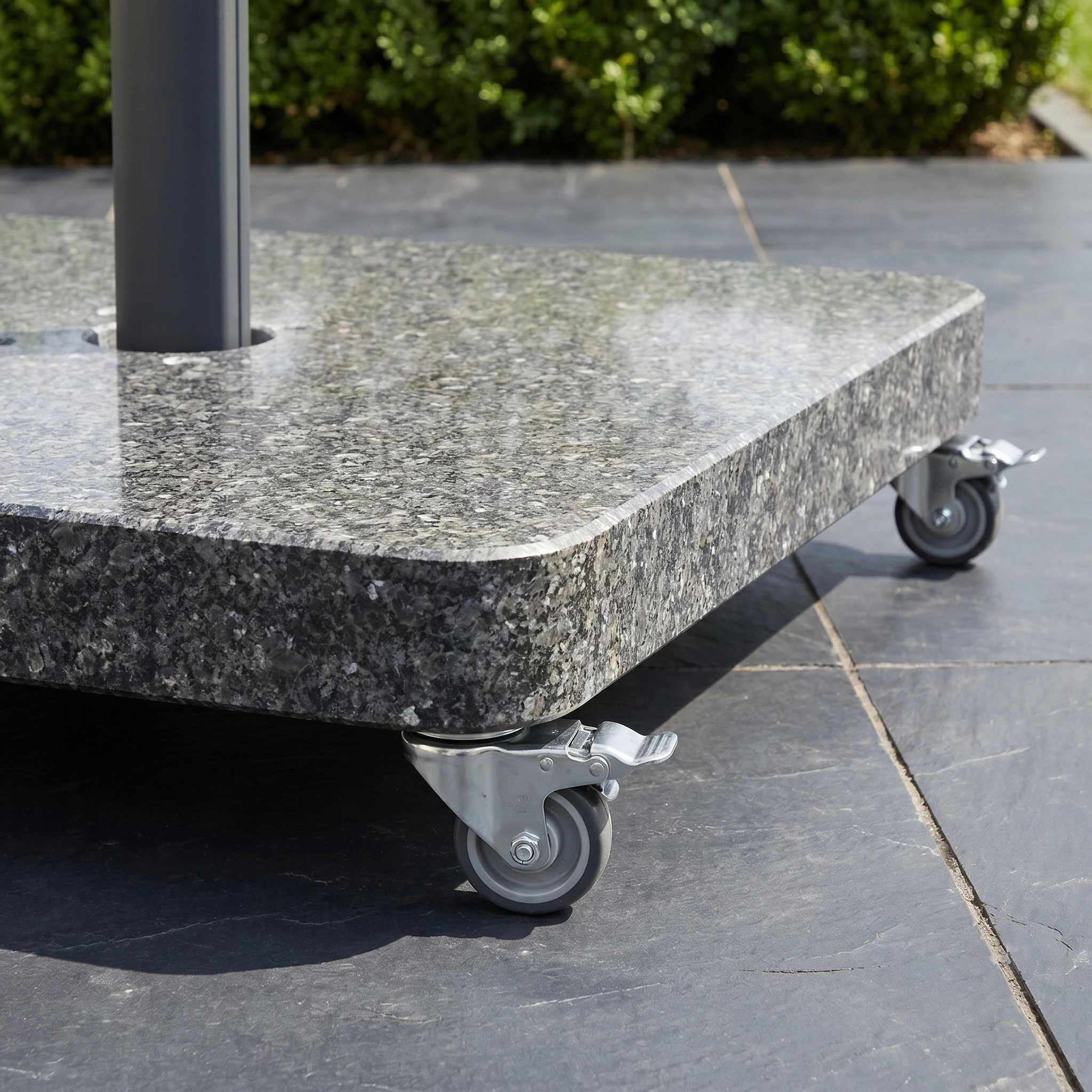 Close-up of a granite umbrella base with wheels, ideal for supporting the Challenger T2 Premium 3.5m x 2.6m Rectangular Cantilever Parasol in Deep Taupe on your outdoor stone patio.