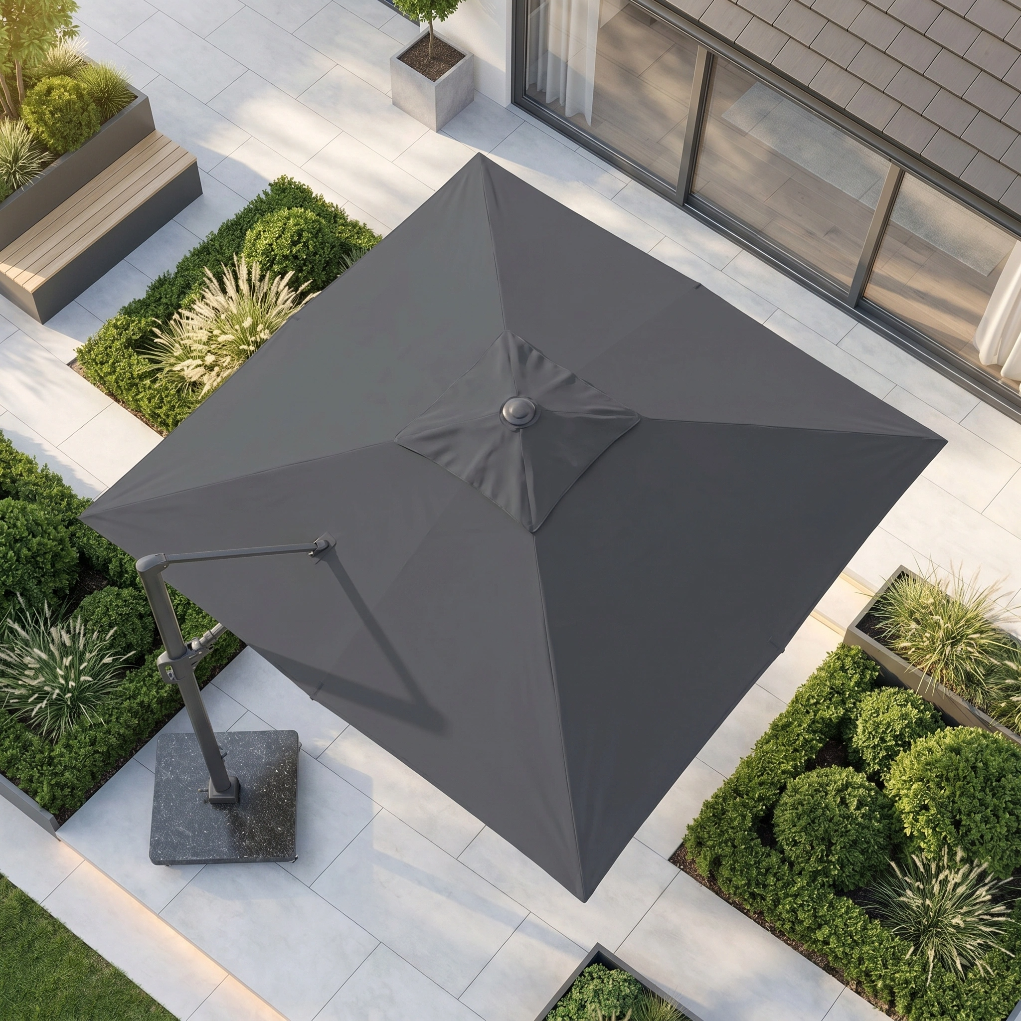 The Challenger T2 3.5m x 2.6m Rectangular Cantilever Parasol in Anthracite with a 90kg granite base provides UV-protected shade for an outdoor area featuring pavers and neatly trimmed green bushes.