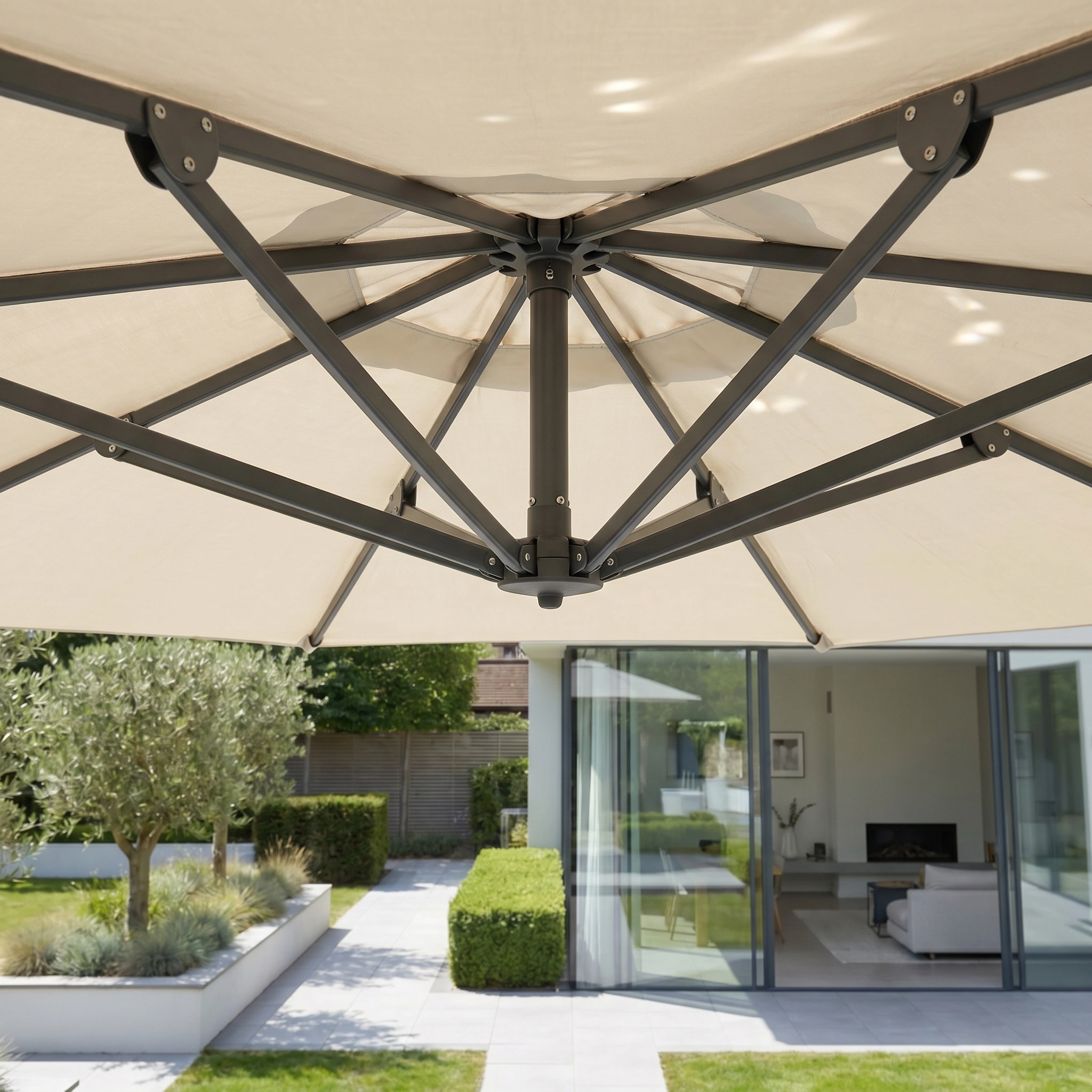 Close-up of the Challenger T2 3.5m x 2.6m Rectangular Cantilever Parasol in Champagne, showing its sleek frame with a modern house and garden in the background.