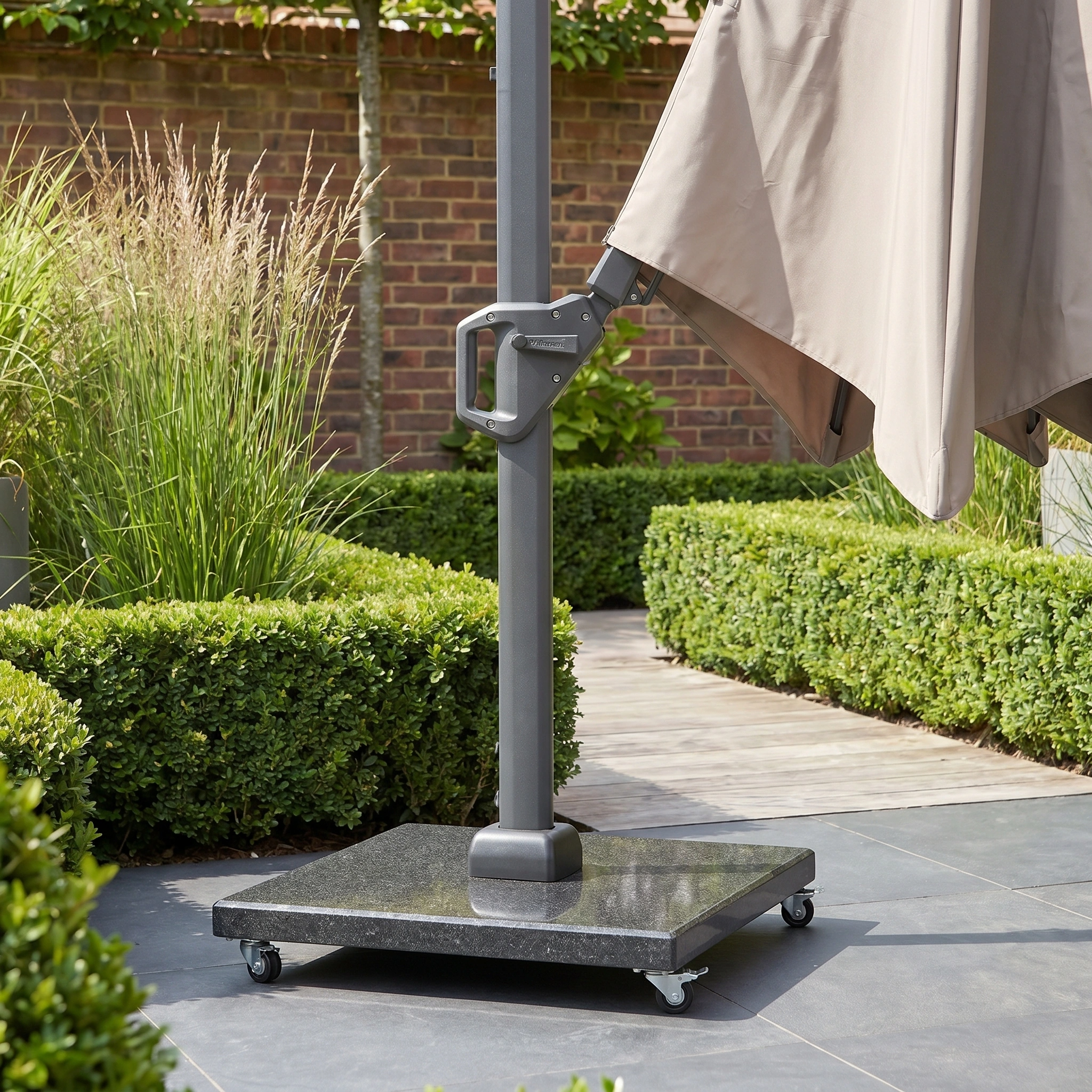 The Challenger T2 3.5m x 2.6m Rectangular Cantilever Parasol in Taupe with a 90kg granite base stands on the patio, surrounded by lush greenery, adding style and premium UV protection to the outdoor space.