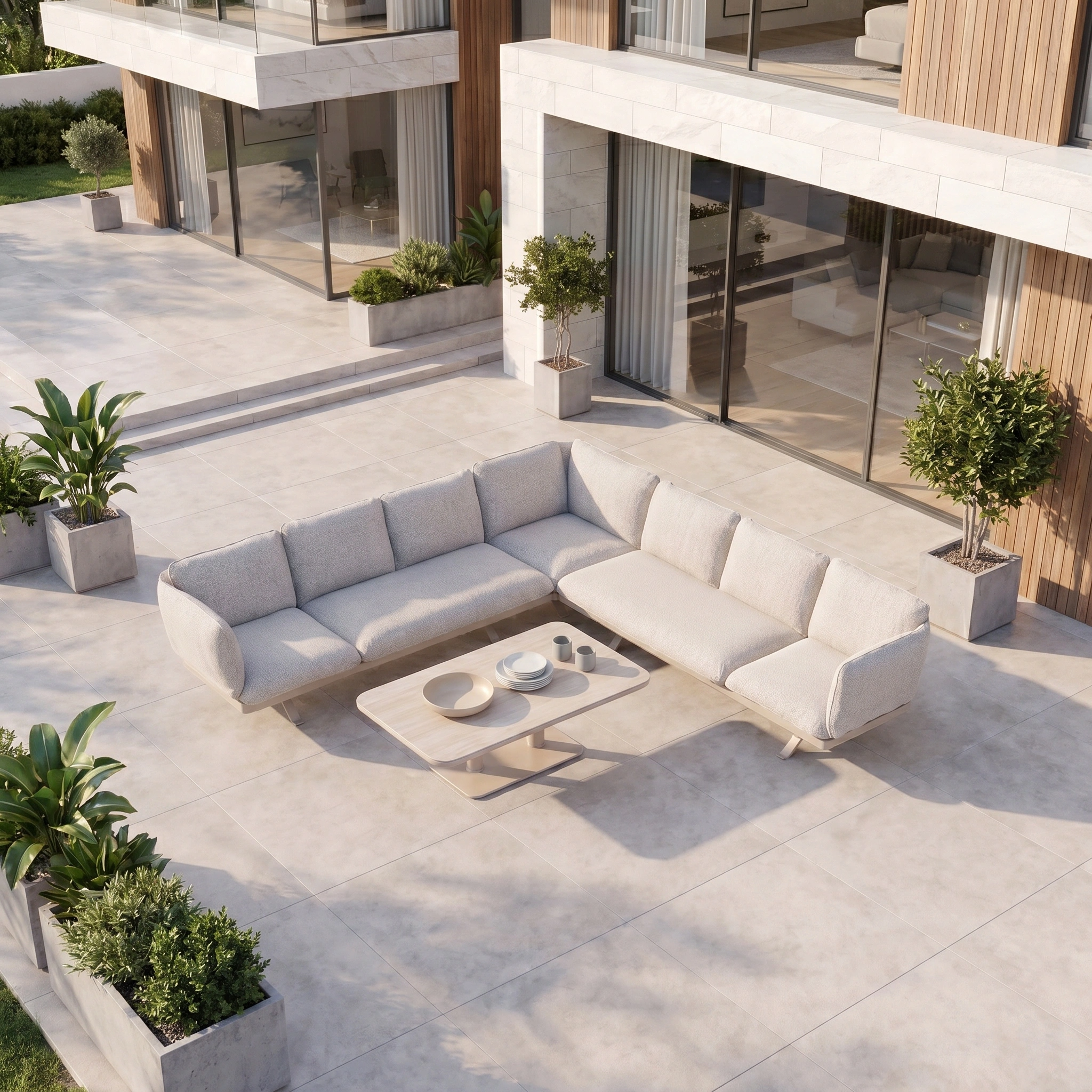 Como Corner Sofa Set with Altura Rising Table in Oatmeal on a tiled patio with potted plants, highlighting outdoor luxury furniture beside a modern house.