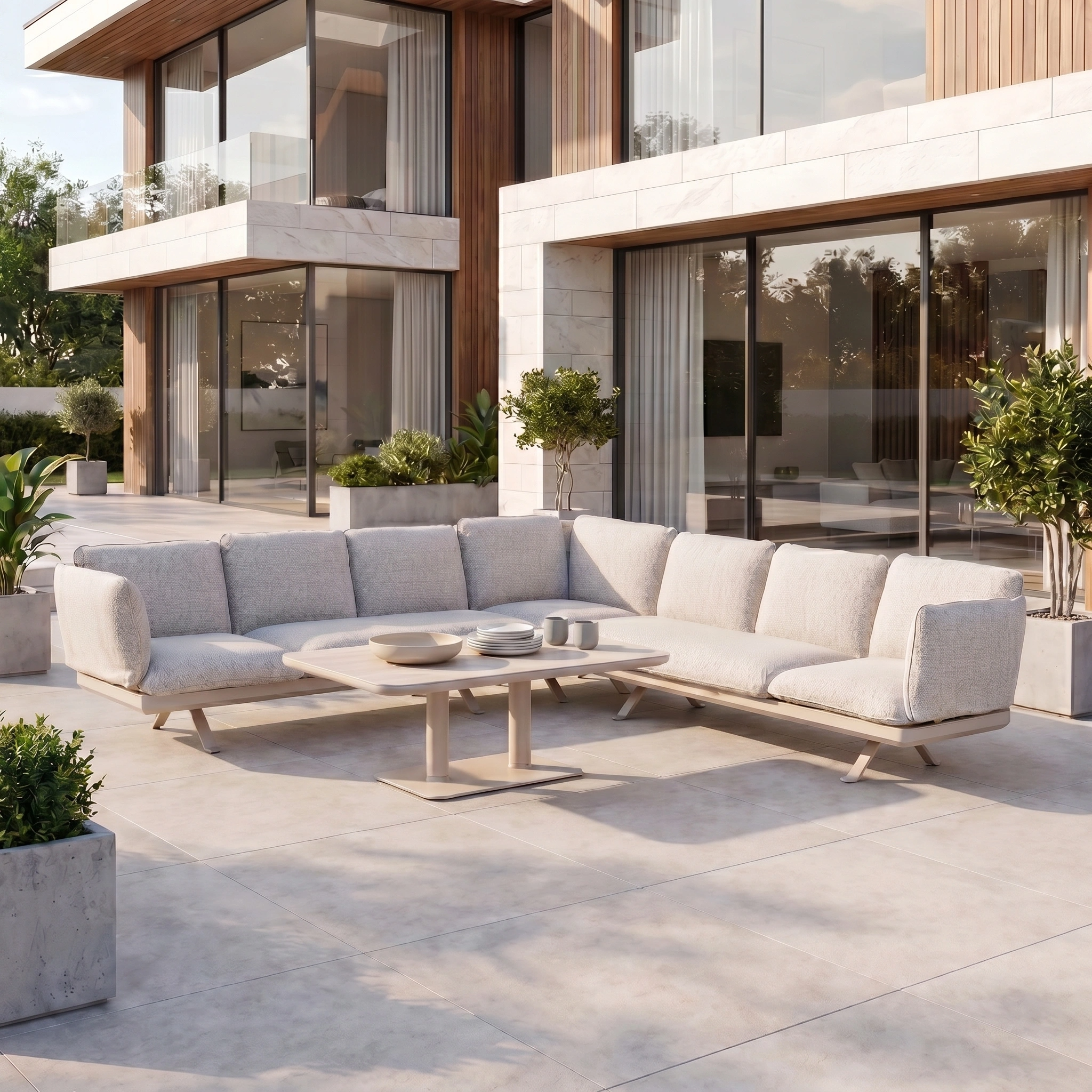 Modern outdoor luxury furniture featuring the Como Corner Sofa Set with Altura Rising Table in Oatmeal on a tiled patio in front of a contemporary house.