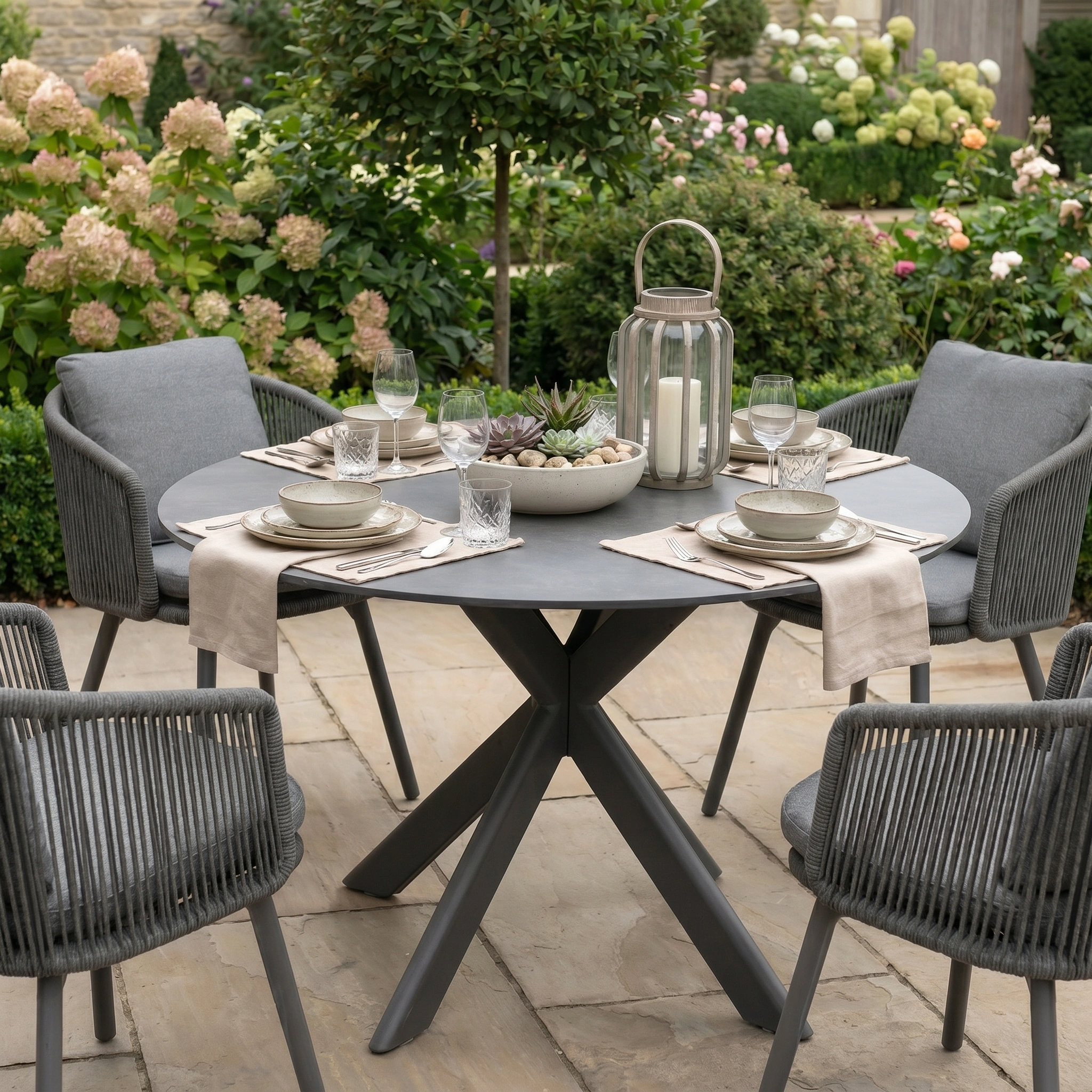 The Dekota 4 Seat Round Rope Dining Set with Albatross Table in Charcoal offers elegant outdoor dining with four chairs, perfect for stylish meals in your garden.