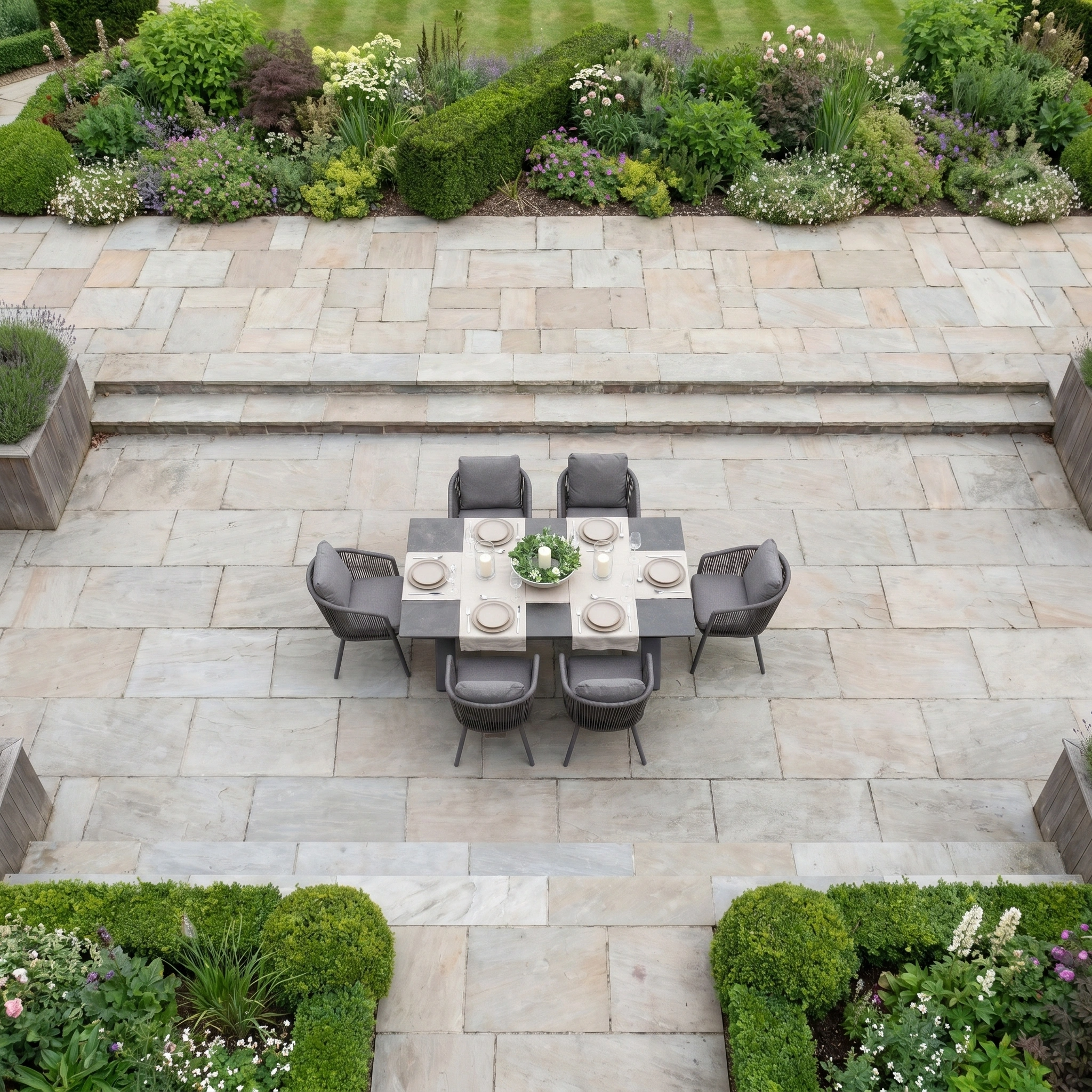 The Dekota 6 Seat Rope Dining Set with Albatross Extending Table in Charcoal is elegantly arranged for dining and surrounded by formal garden landscaping.