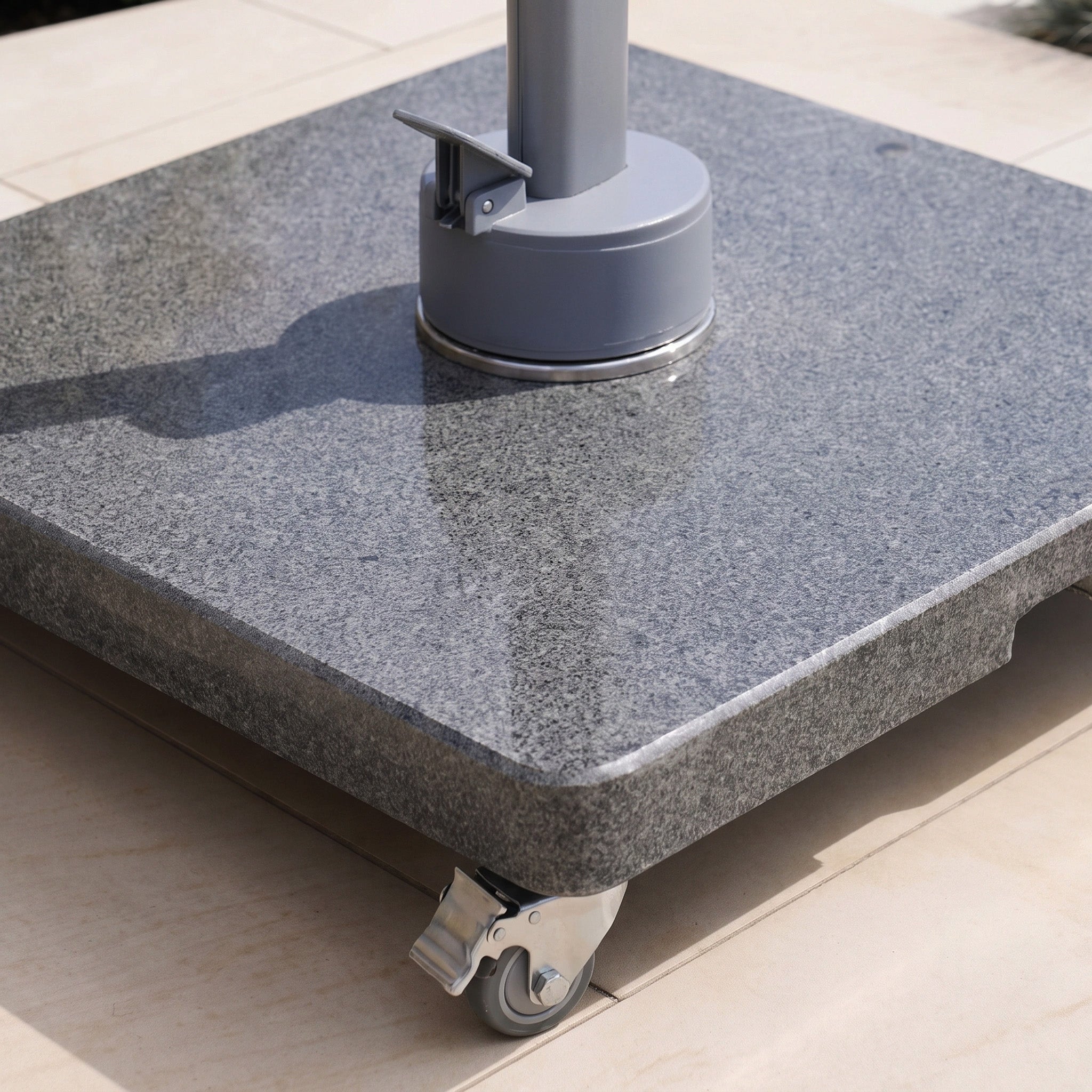 Close-up of the Granite 120kg Cantilever Parasol Base With Wheels on a tiled outdoor surface.