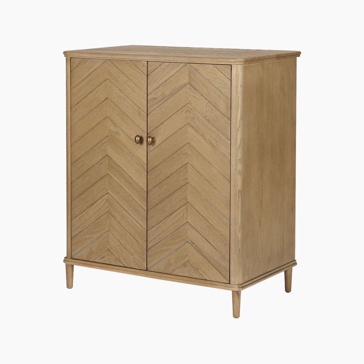 The Hadley Herringbone Drinks Cabinet in Natural features chevron pattern doors with round knobs, stands on four barrel legs, and is crafted from natural oak for a timeless home bar solution.