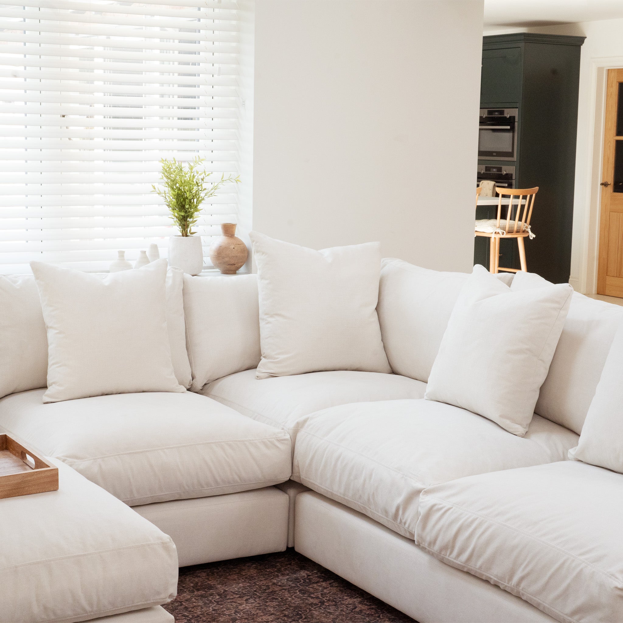 The Hampshire Modular Corner Sofa in Ivory boasts plush duck feather and down cushions and a frame crafted from sustainably sourced hardwood, offering lasting comfort and quality for bright living spaces.
