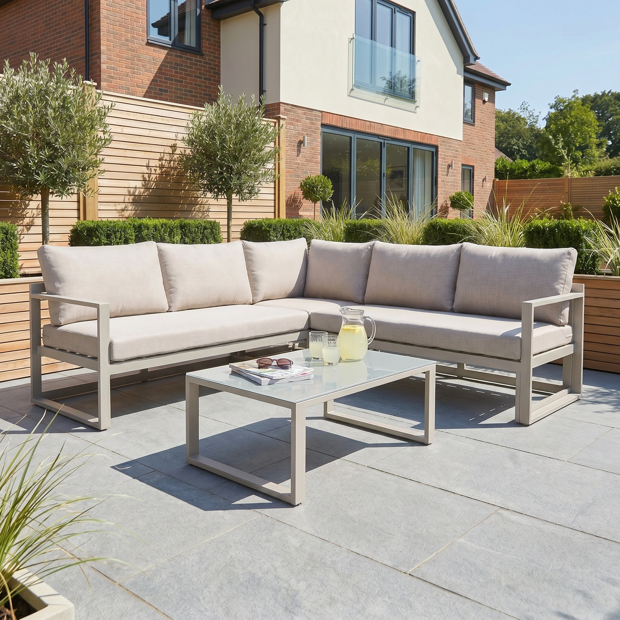 Sunny modern patio featuring the Havana Corner Group Set in Latte with reclining seats and a matching coffee table, perfect for relaxing outdoors.