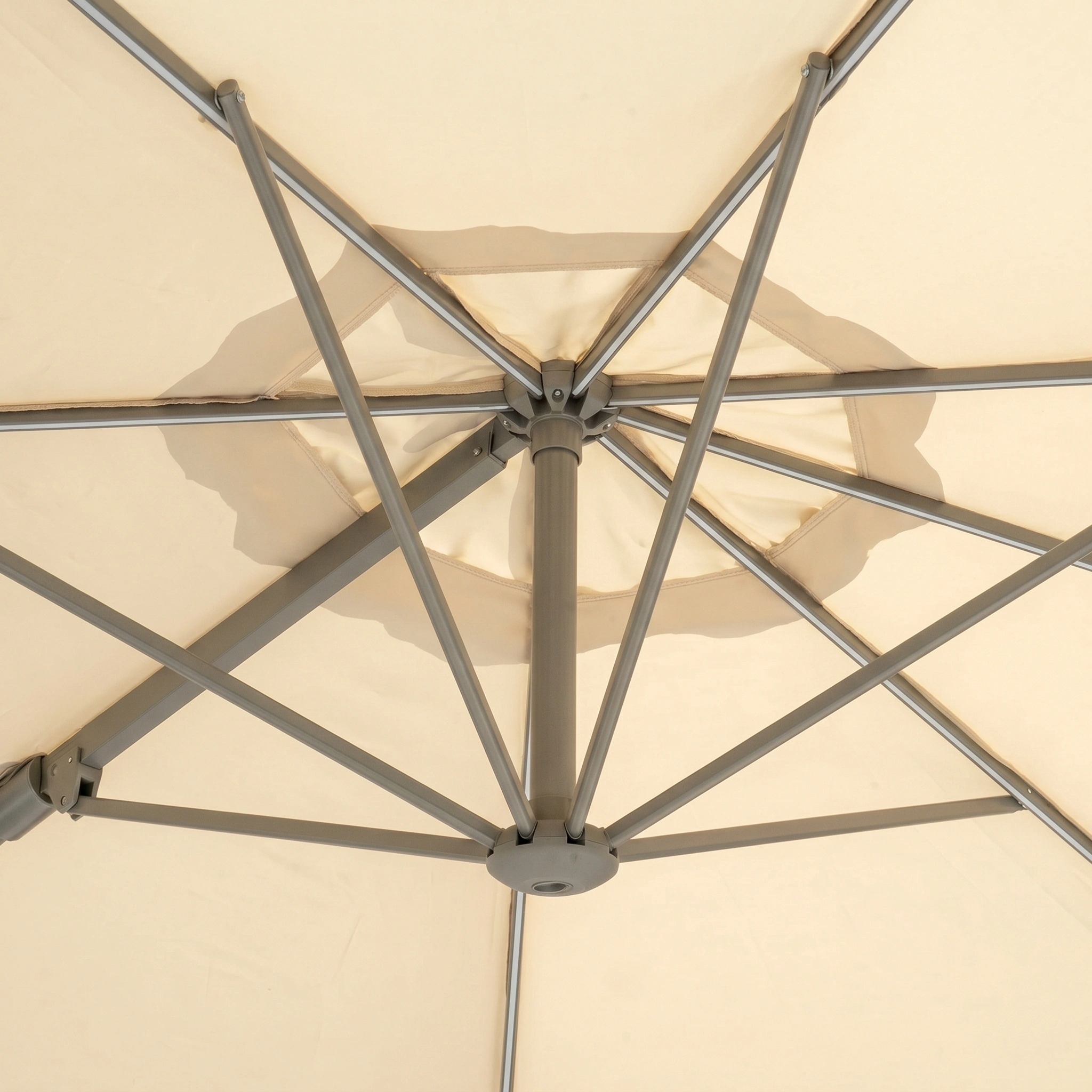 Close-up of metal spokes supporting the underside of the Hera 3m Round Cantilever Parasol with LED Lighting in Beige, perfect as a UV50+ garden umbrella.