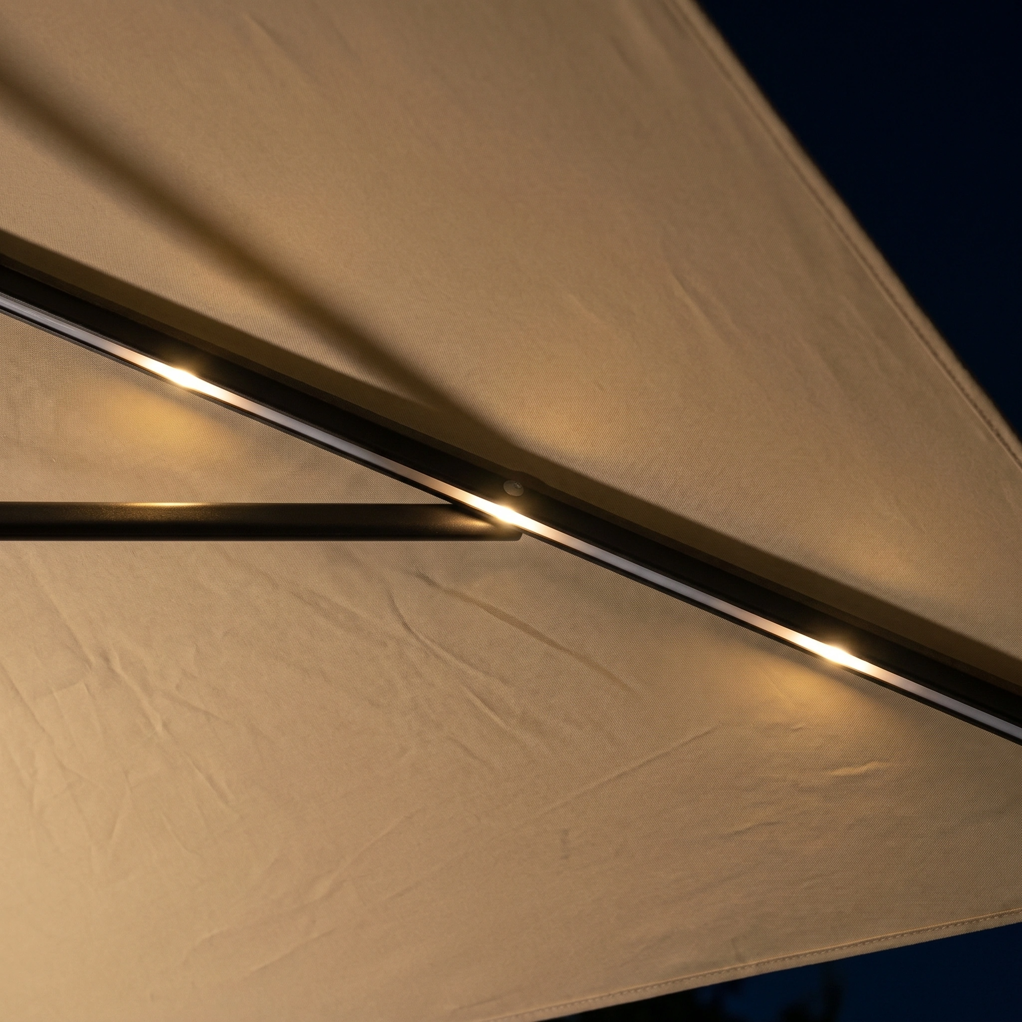 Close-up of the Hera 3m Round Cantilever Parasol in Beige, featuring built-in LED lighting for a glowing nighttime ambiance. This UV50+ garden umbrella combines stylish illumination and protection for your outdoor space.