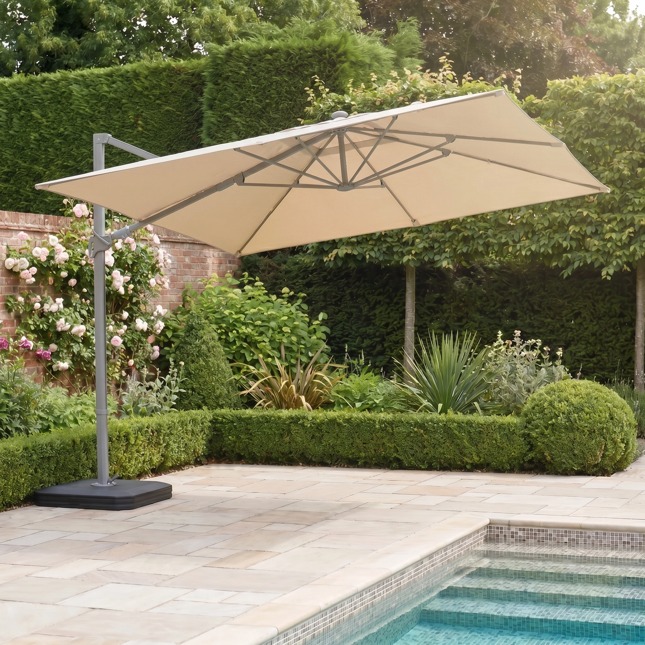 The Hera 3m x 2m Rectangular Cantilever Parasol with LED Lighting in Beige provides shade beside a pool in a landscaped garden.