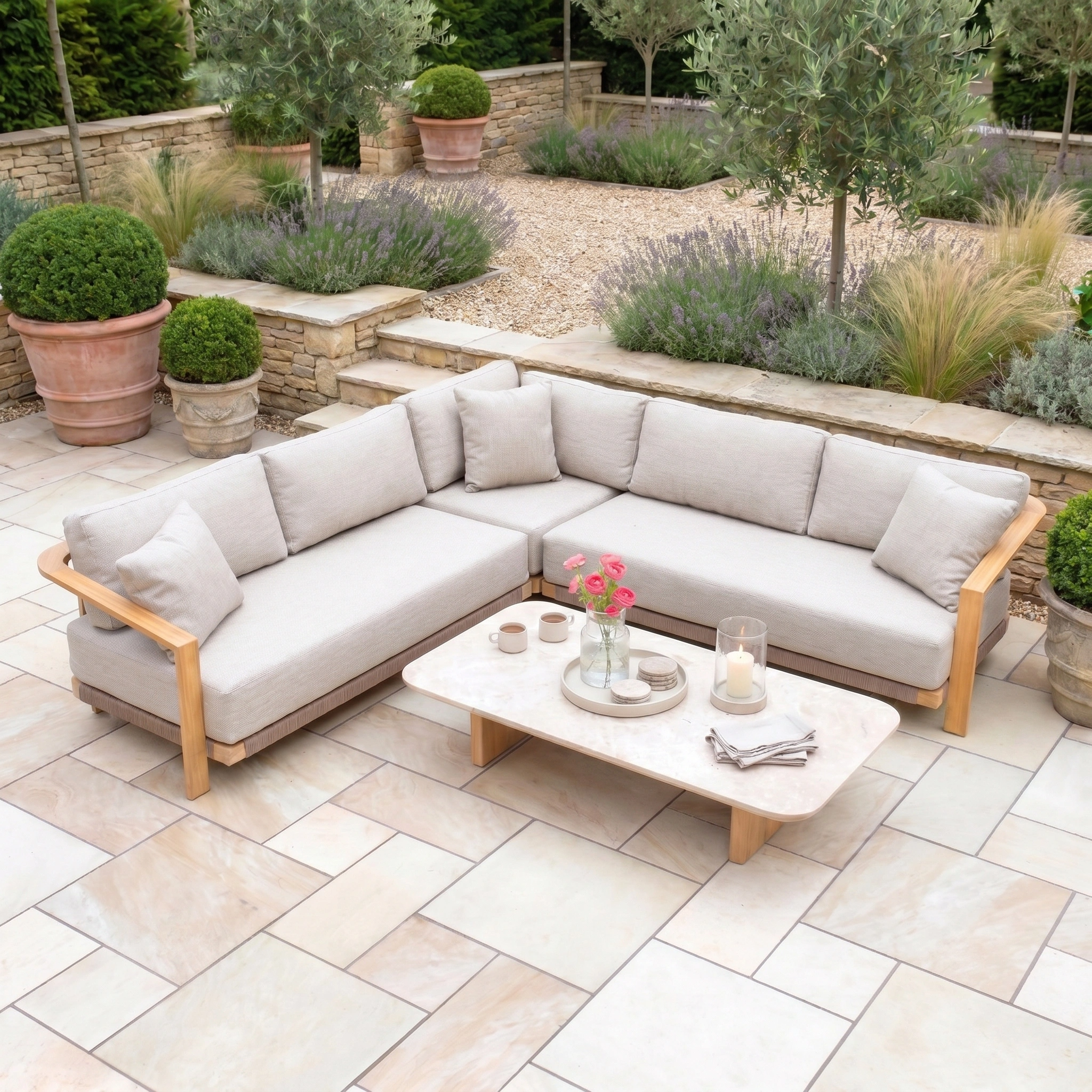 The Tivoli Corner Set with Marble Coffee Table in Fawn features a light beige sectional and marble table, creating an elegant outdoor retreat on a paved patio.