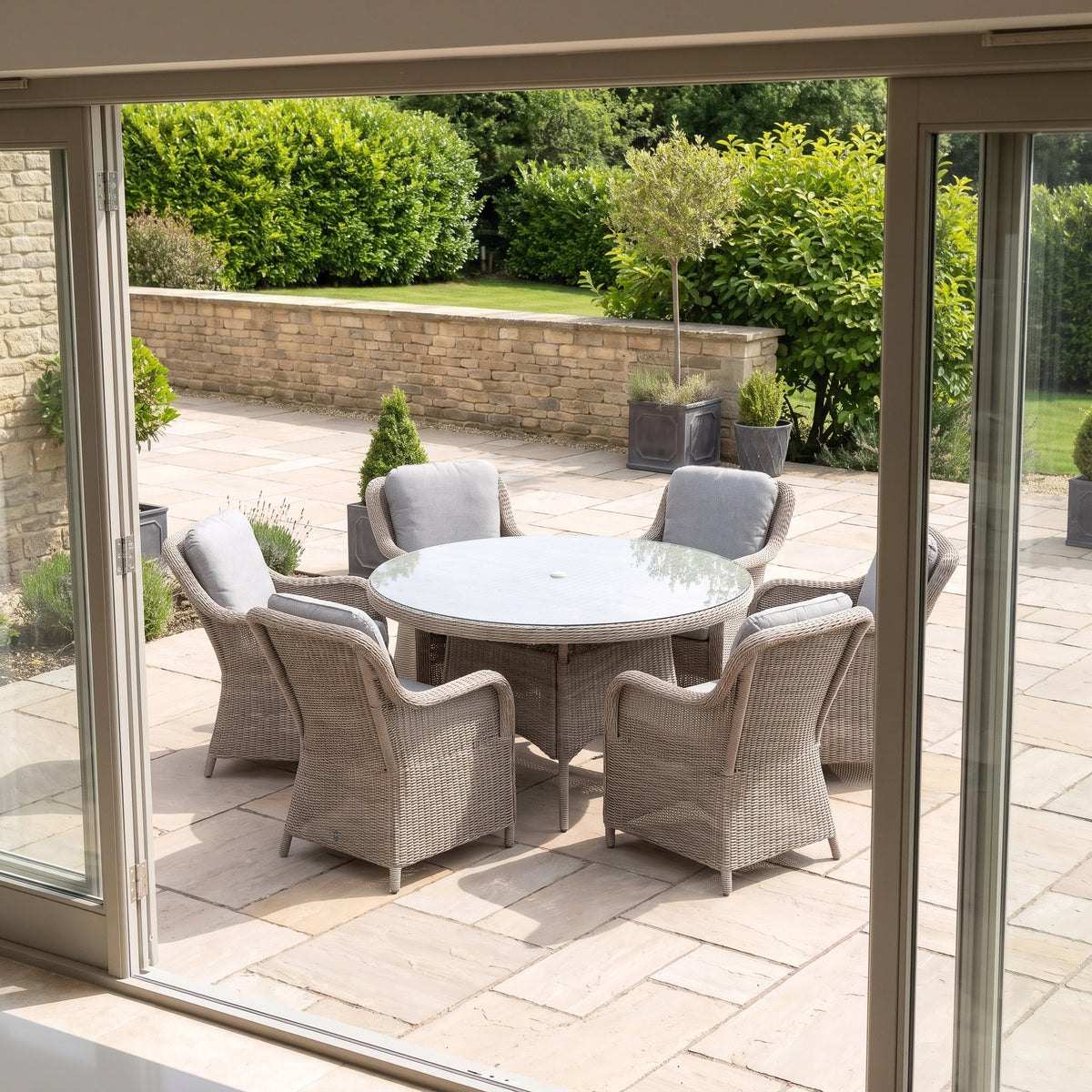 a table and chairs outside with a glass door