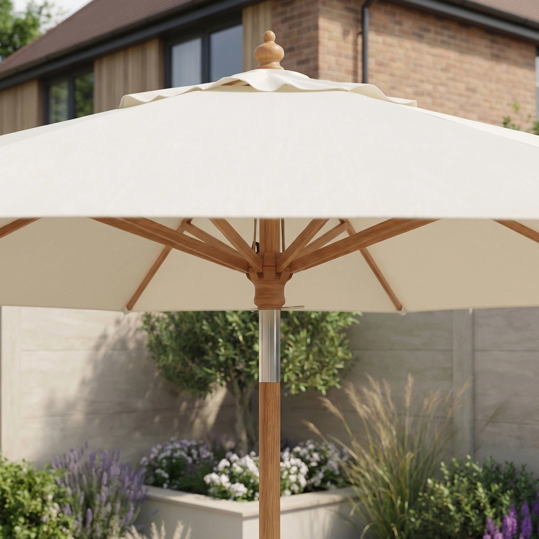 The Kratos 2.5m Round Wooden Parasol in Beige stands open in a sunny garden, offering stylish UV 50+ sun protection with plants and a house visible in the background.