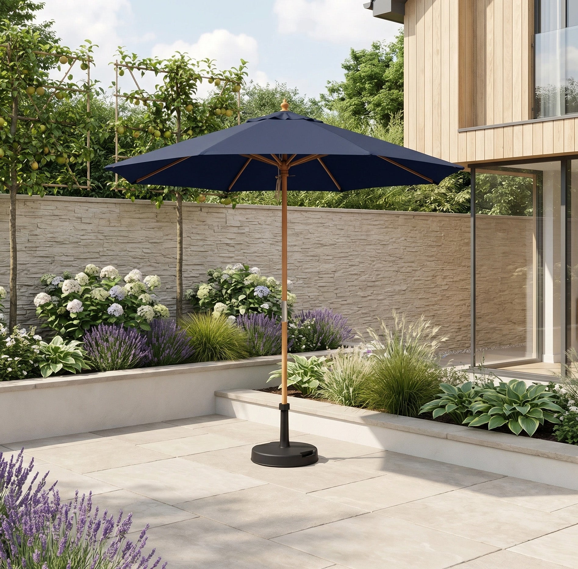The Kratos 2.5m Round Wooden Parasol in Navy, with UV 50+ protection, stands on a tiled terrace surrounded by vibrant garden plants and flowers.