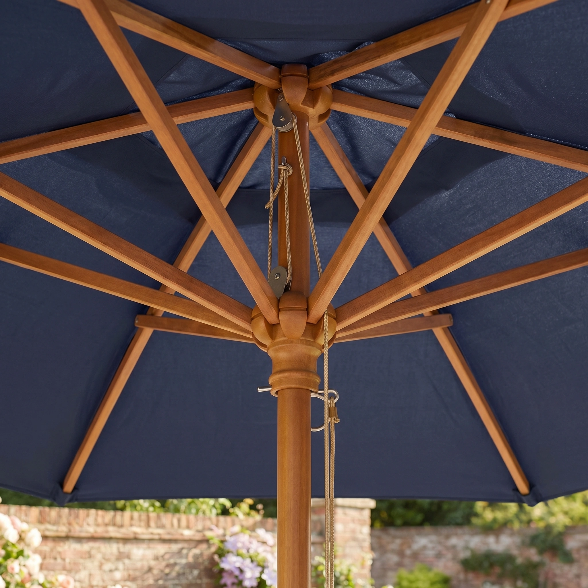 Close-up of the Kratos 3m x 2m Rectangular Wooden Parasol in Navy, featuring a sturdy frame and support beams, set in a garden.