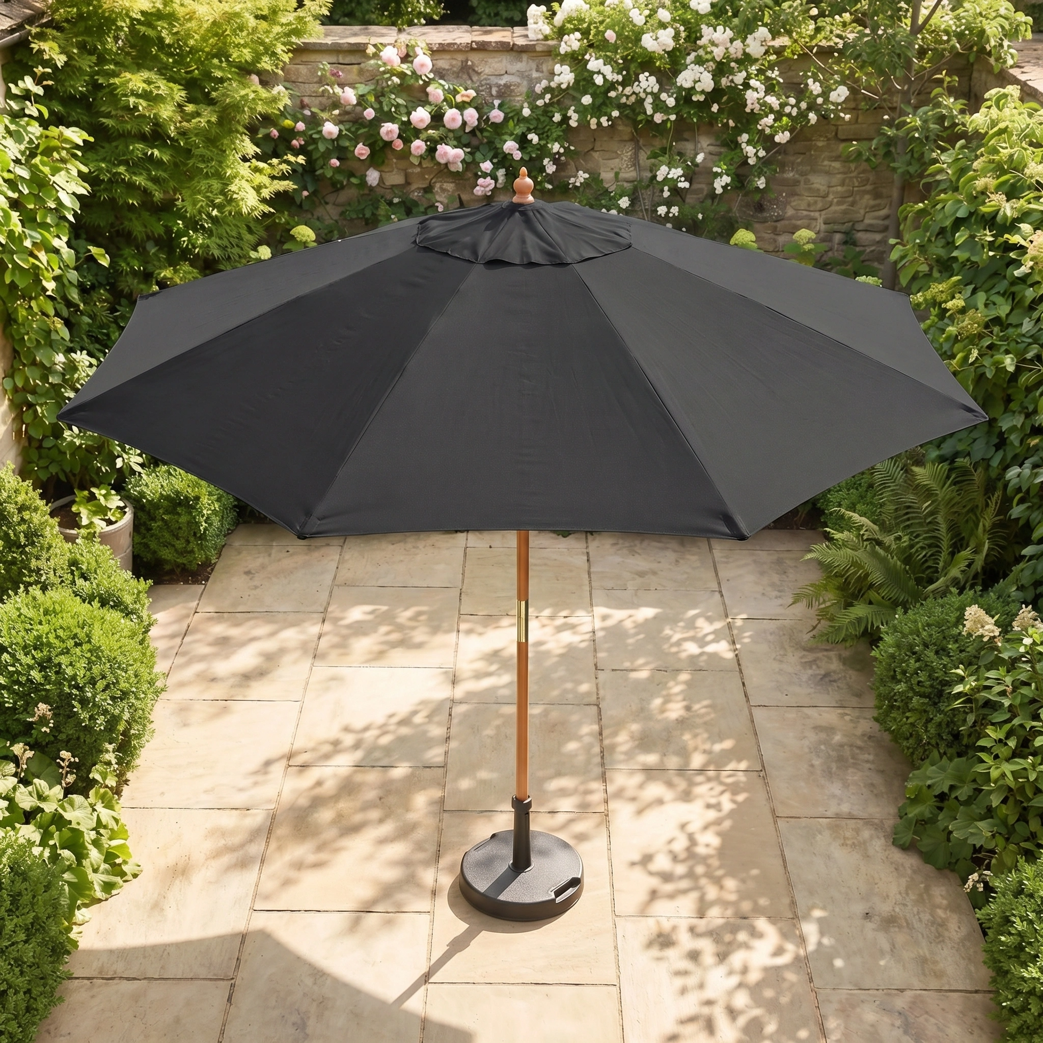 The Kratos 3m Round Wooden Parasol in Black is a stylish, collapsible UV sun protector—perfect for your garden retreat, ideal on a stone terrace and surrounded by greenery.