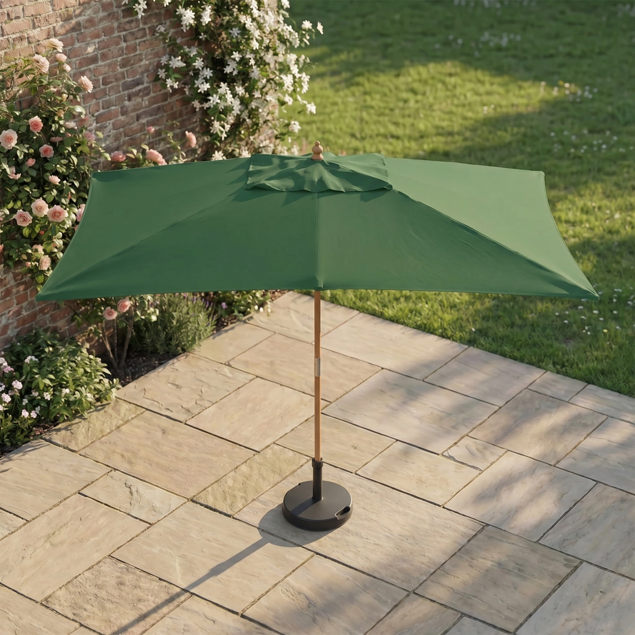 Kratos 3m x 2m Rectangular Wooden Parasol in Green set on a stone-tiled terrace, with flowers and grass in the background.