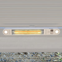 The PergoSTET Wifi & Bluetooth Heater in Latte, with two round lights, is mounted under a gray overhang and glowing—perfect as a remote-controlled heater for your pergola ceiling.