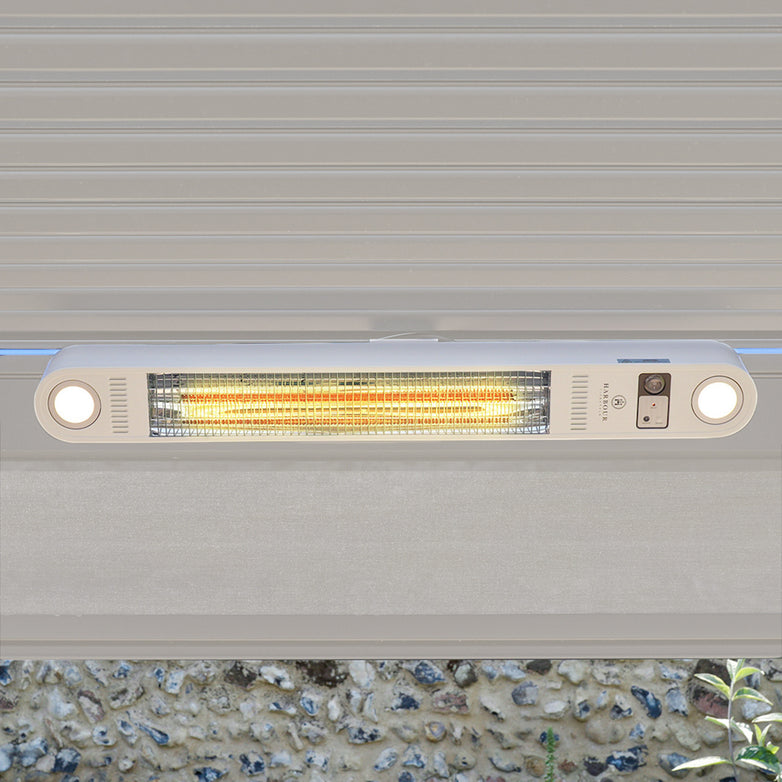 The PergoSTET Wifi & Bluetooth Heater in Latte, with two round lights, is mounted under a gray overhang and glowing—perfect as a remote-controlled heater for your pergola ceiling.