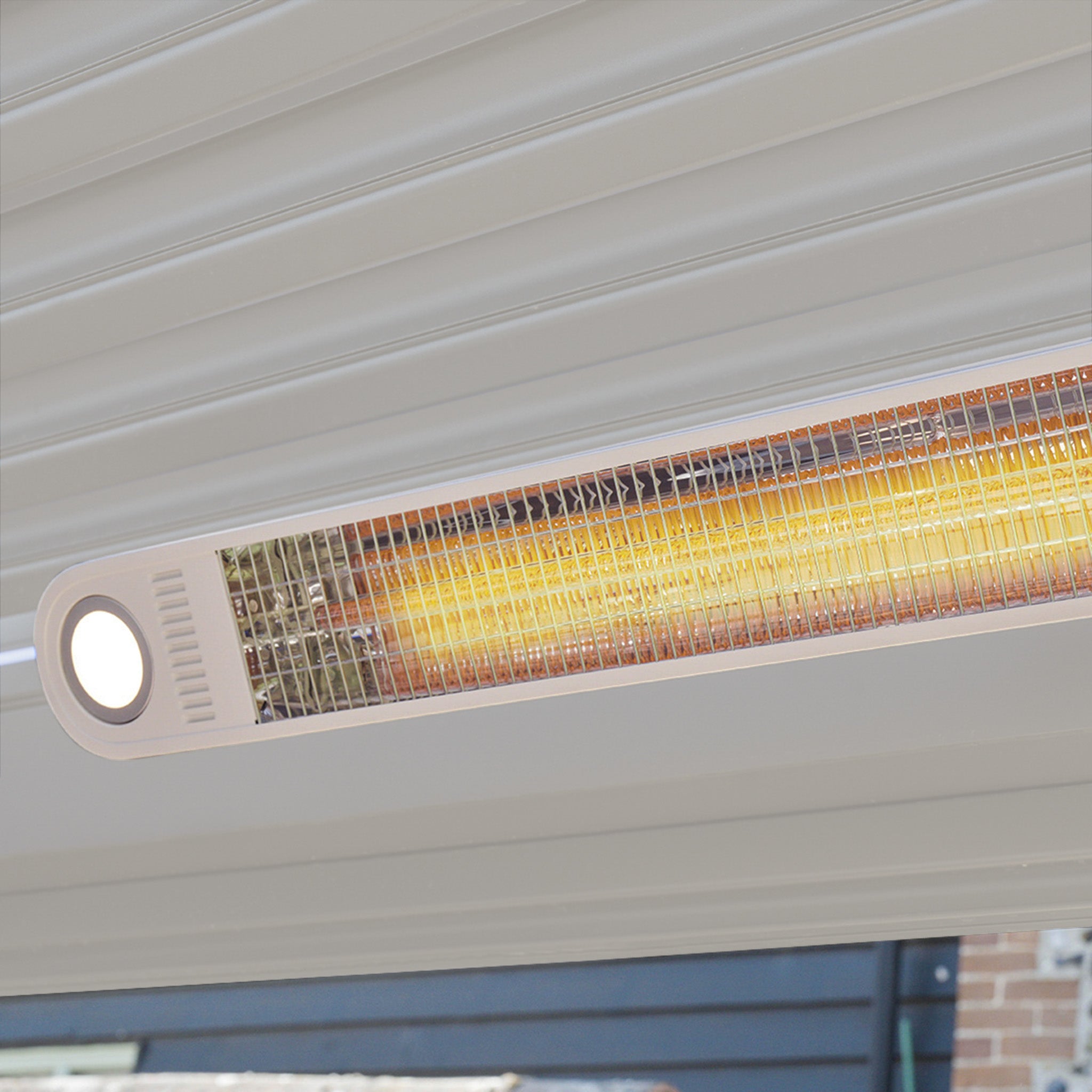 The FREE PergoSTET Wifi & Bluetooth Heater in Latte glows softly under a white pergola ceiling, adding warmth and comfort to your outdoor space on cool evenings.