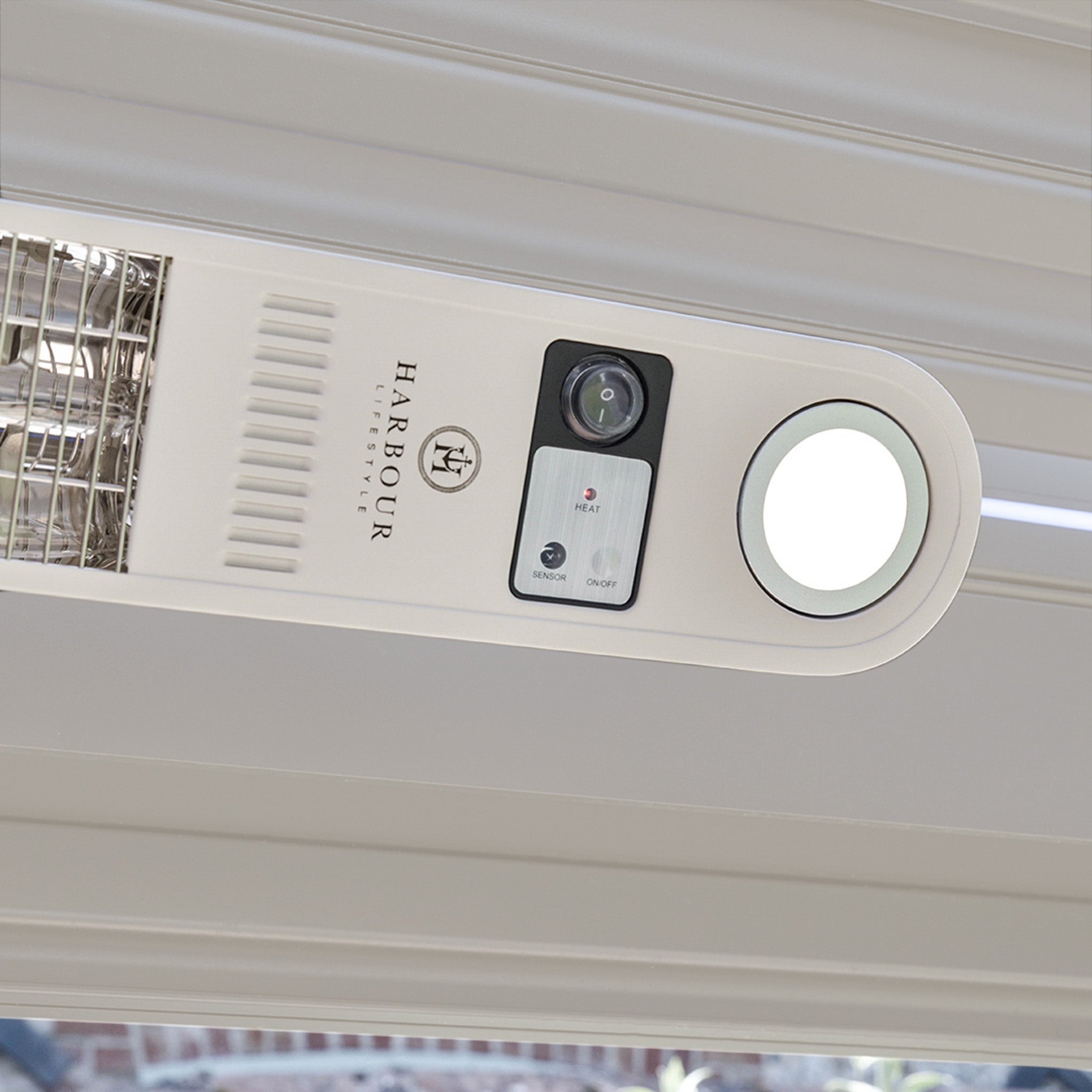 Close-up of a Harbour Technologies security camera and light installed on a ceiling next to a sleek PergoSTET Wifi & Bluetooth Heater in Latte.