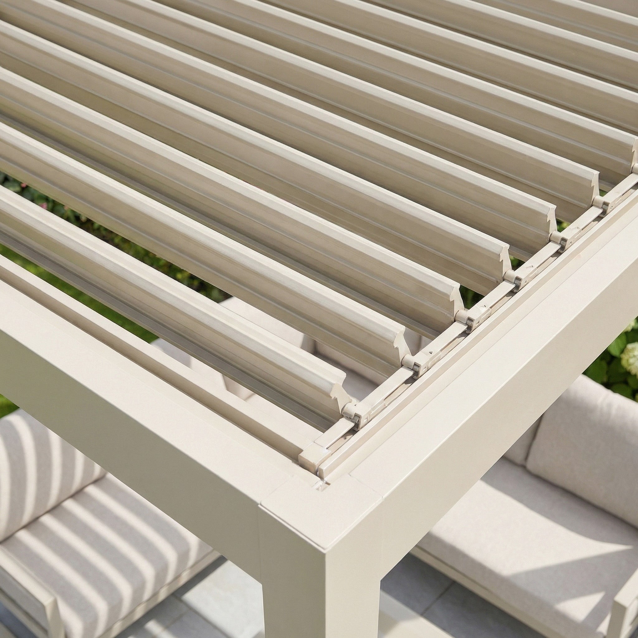 The PergoSTET Lite 3m x 4m Metal Rectangular Pergola in Latte features tilting louvres that create striped shadows and provide adjustable outdoor shade over your seating area.