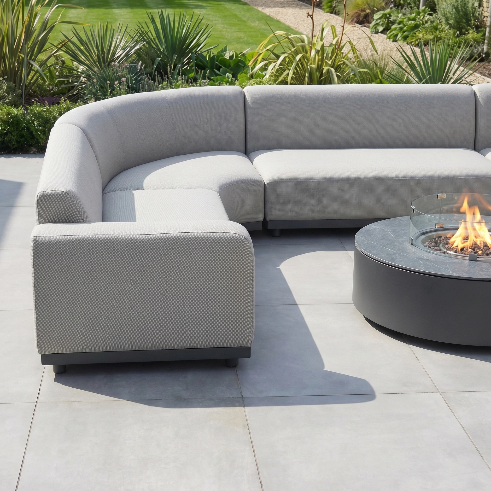 The Luna U-Shape Outdoor Fabric Curved Corner Group with Round Firepit Coffee Table in Oyster Grey offers stylish comfort—perfect outdoor furniture for relaxing evenings on the patio.