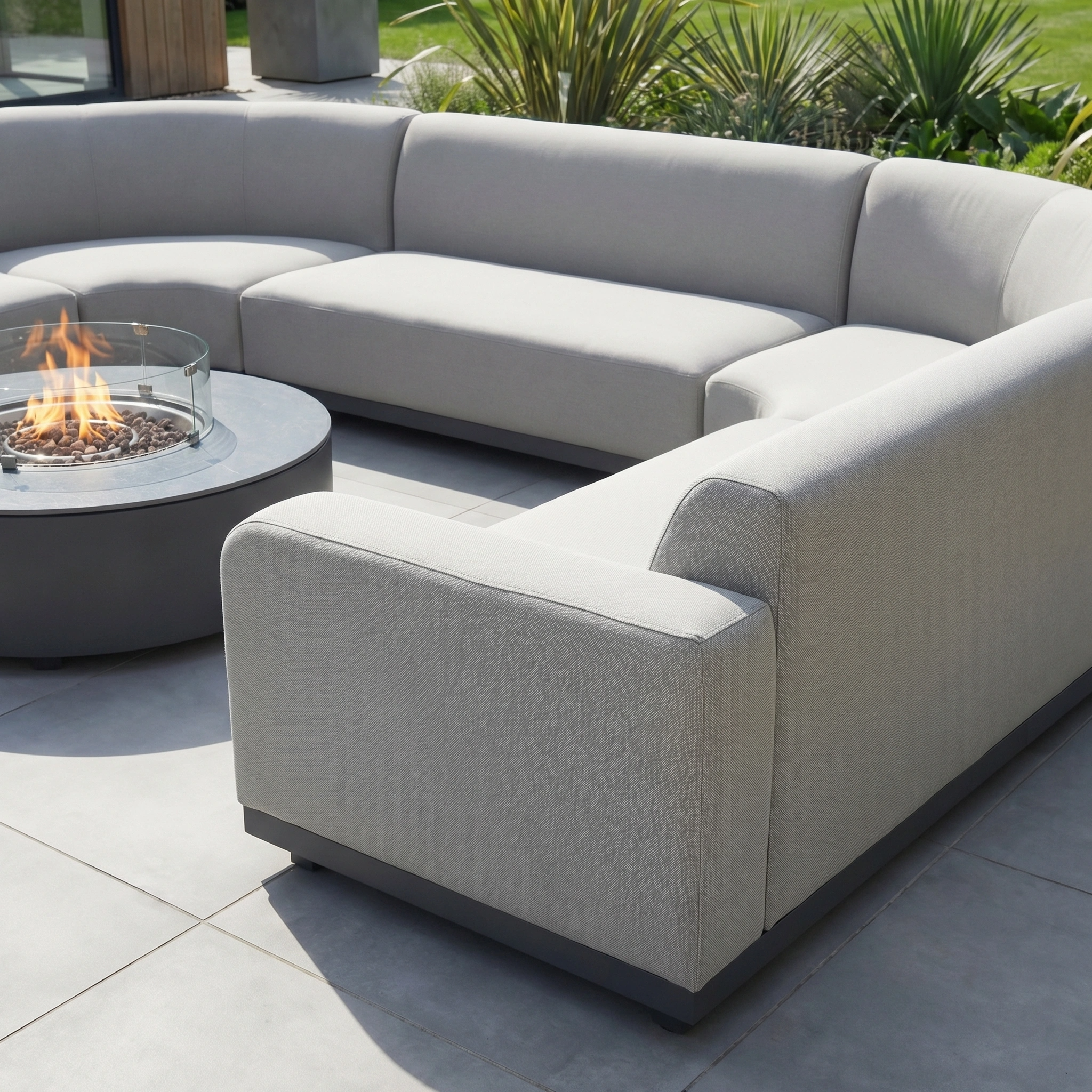 Modern outdoor furniture: the Luna U-Shape Outdoor Fabric Curved Corner Group with Round Firepit Coffee Table in Oyster Grey on a tiled patio.