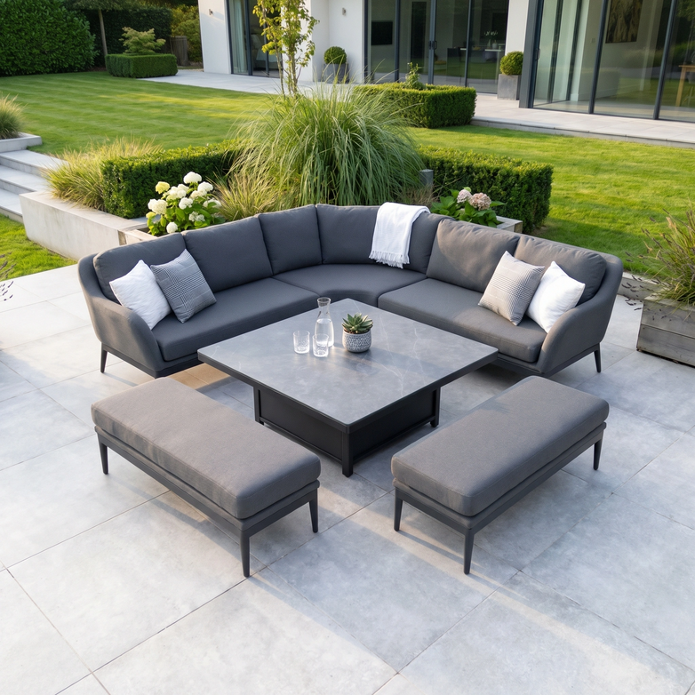 The Luna Deluxe Outdoor Fabric Square Corner Dining Set with Rising Table in Grey features gray cushioned seating and benches, crafted from all-weather materials, perfect for modern terraces.