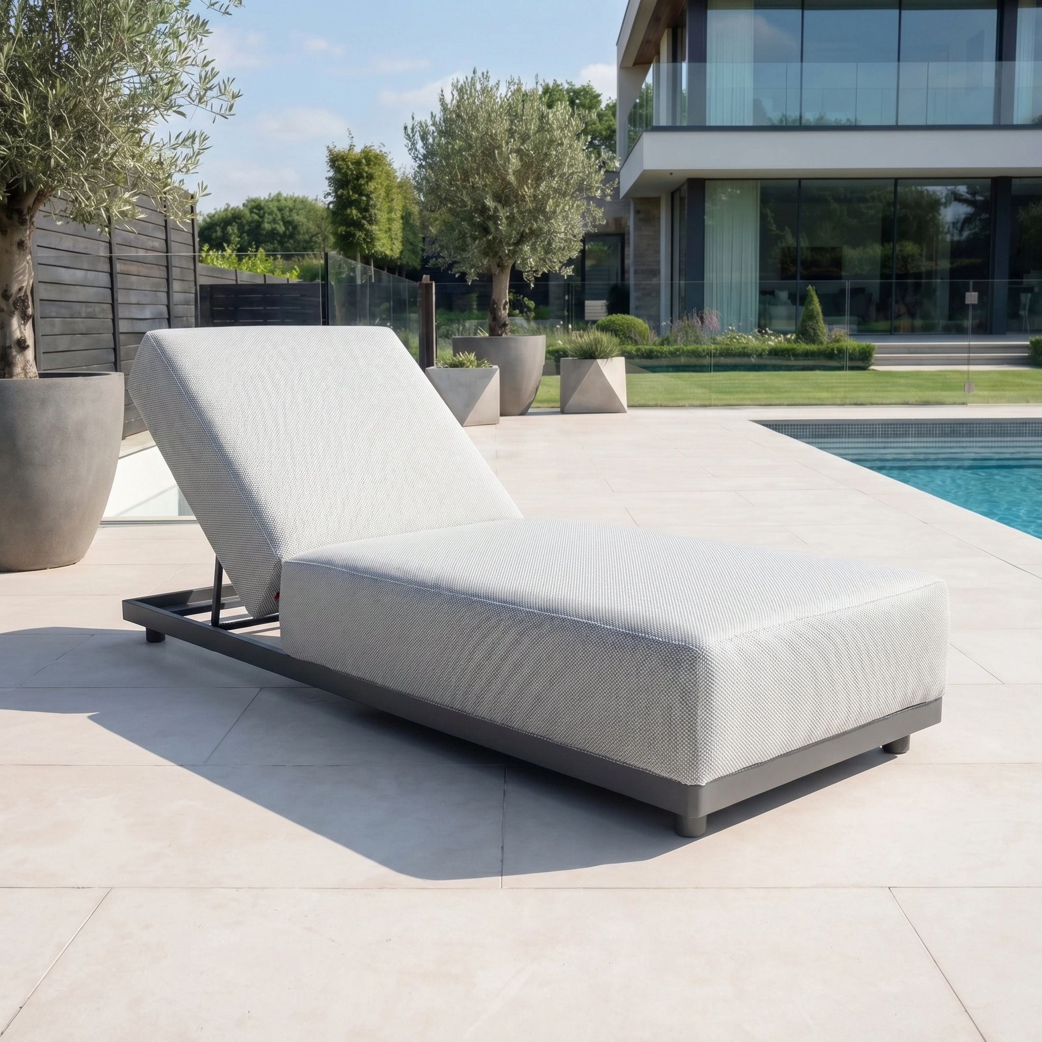 The Luna Outdoor Fabric Deluxe Sun Lounger in Oyster Grey is perfect as stylish garden furniture, complementing any patio or poolside near a modern home.