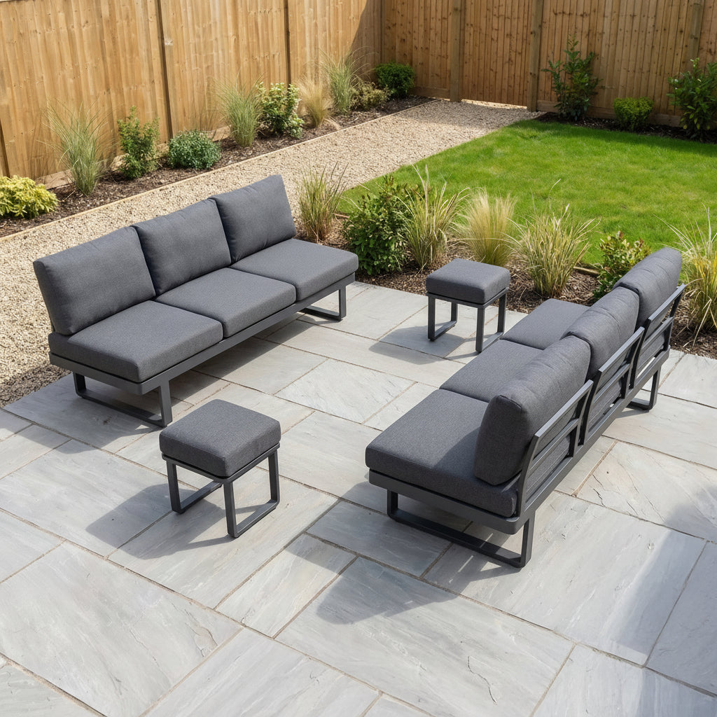 The Lyra Corner Dining Set in Charcoal features gray cushions, a dining table, and four place settings—perfect for adding elegance to any stone patio.