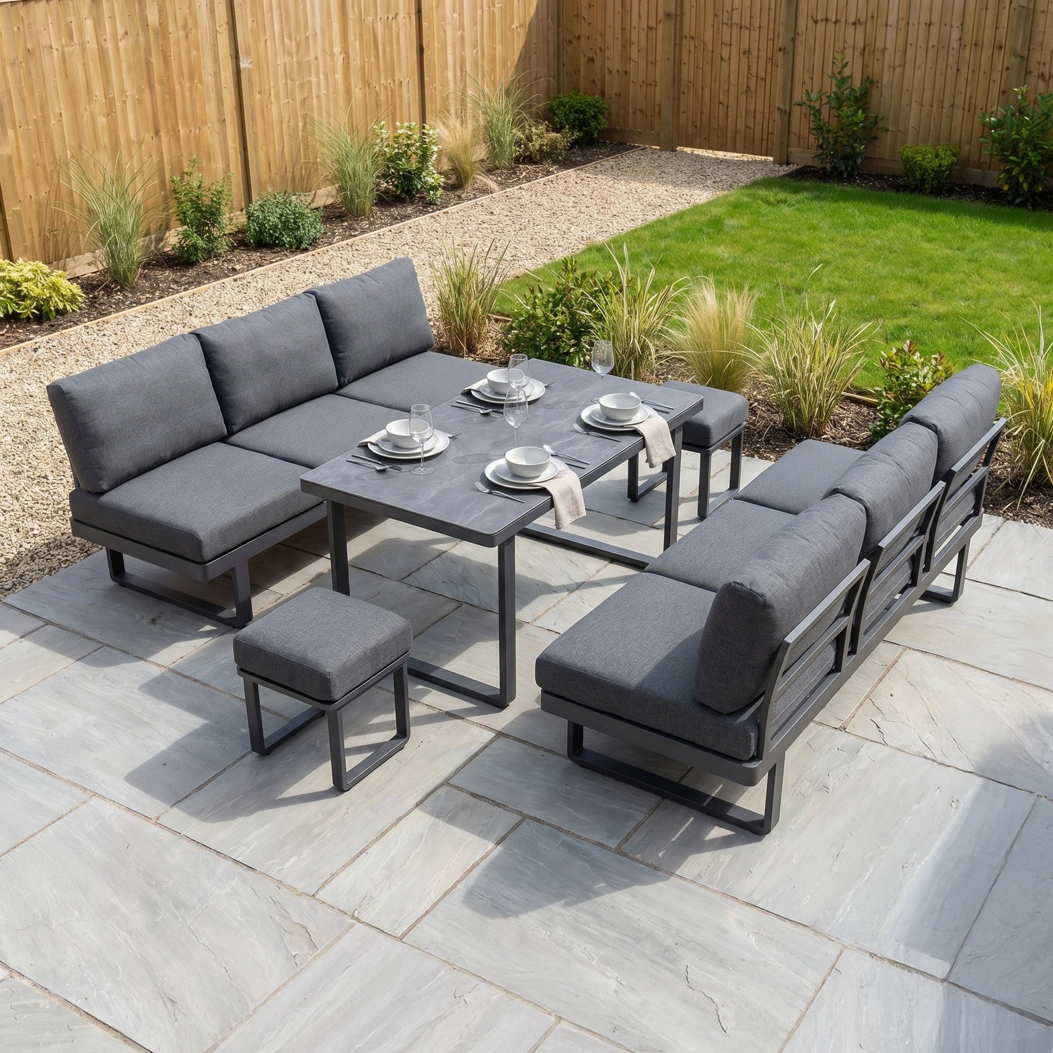 The Lyra Corner Dining Set in Charcoal features a gray aluminum frame with table, benches, and chairs—an ideal choice for stylish outdoor dining on your patio or in your landscaped backyard.