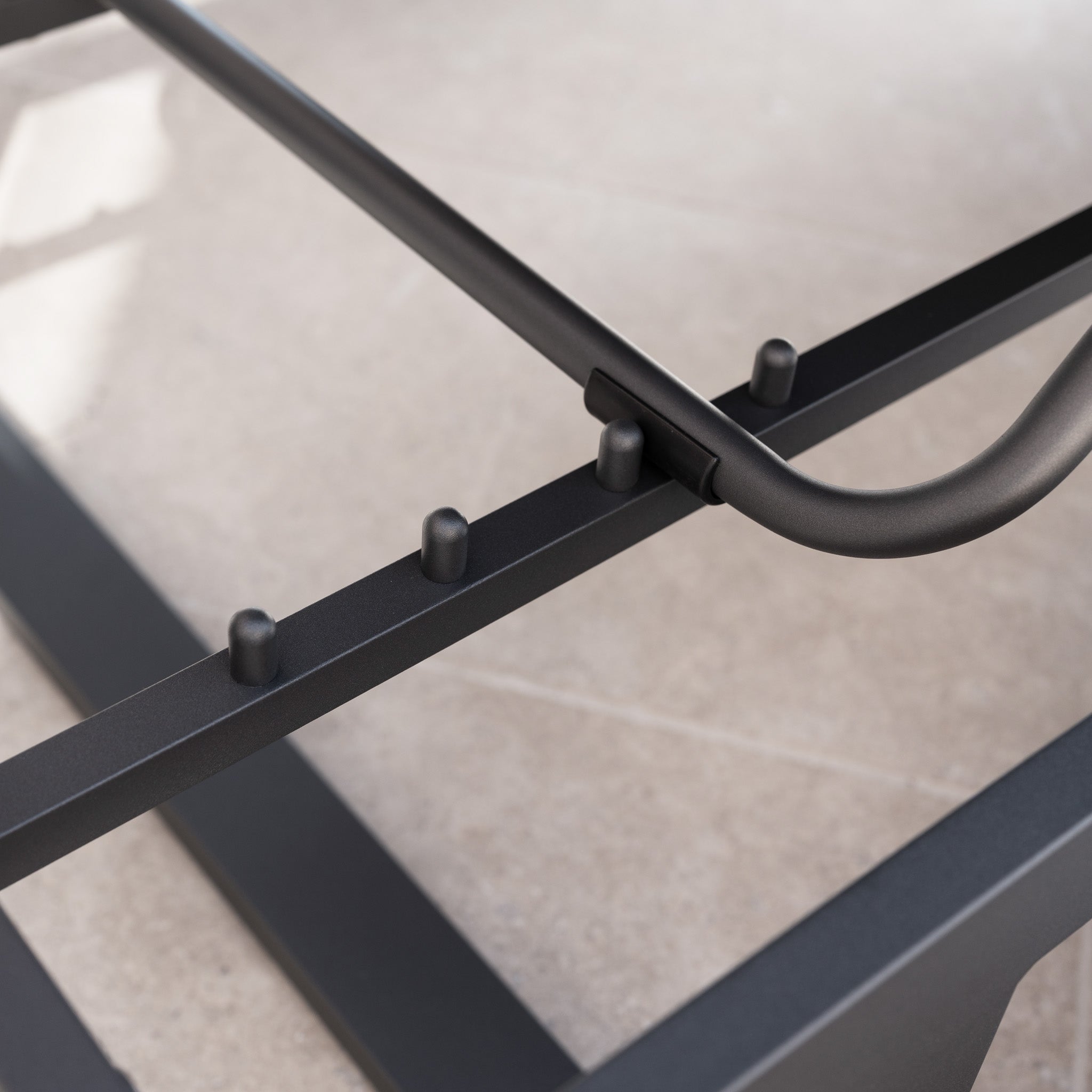 Close-up of an aluminium frame with adjustable pegs and a curved bar, part of the Lyra Corner Dining Set in Charcoal—ideal for adding stylish, durable seating to your garden.