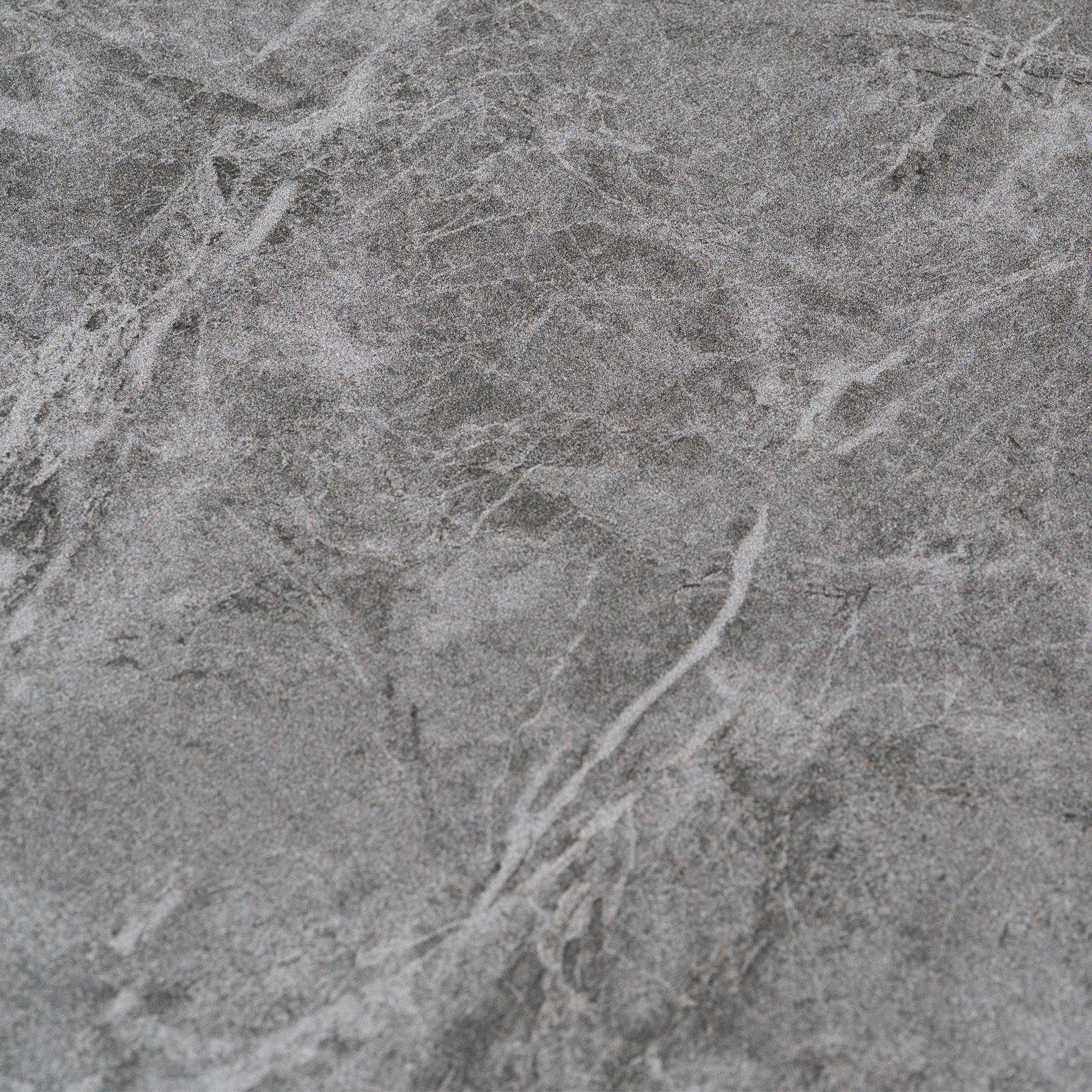 Gray stone surface with natural white veins and textured patterns, ideal for pairing with an aluminum frame or upgrading outdoor furniture such as the Lyra Corner Dining Set in Charcoal.