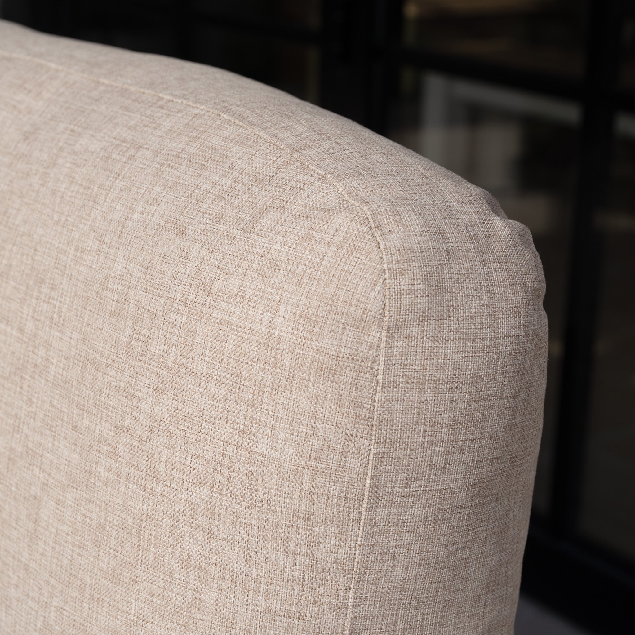 Close-up of a beige fabric backrest from the Lyra Corner Dining Set in Latte, showcasing its textured elegance against a dark, blurred background—ideal for sophisticated outdoor spaces.
