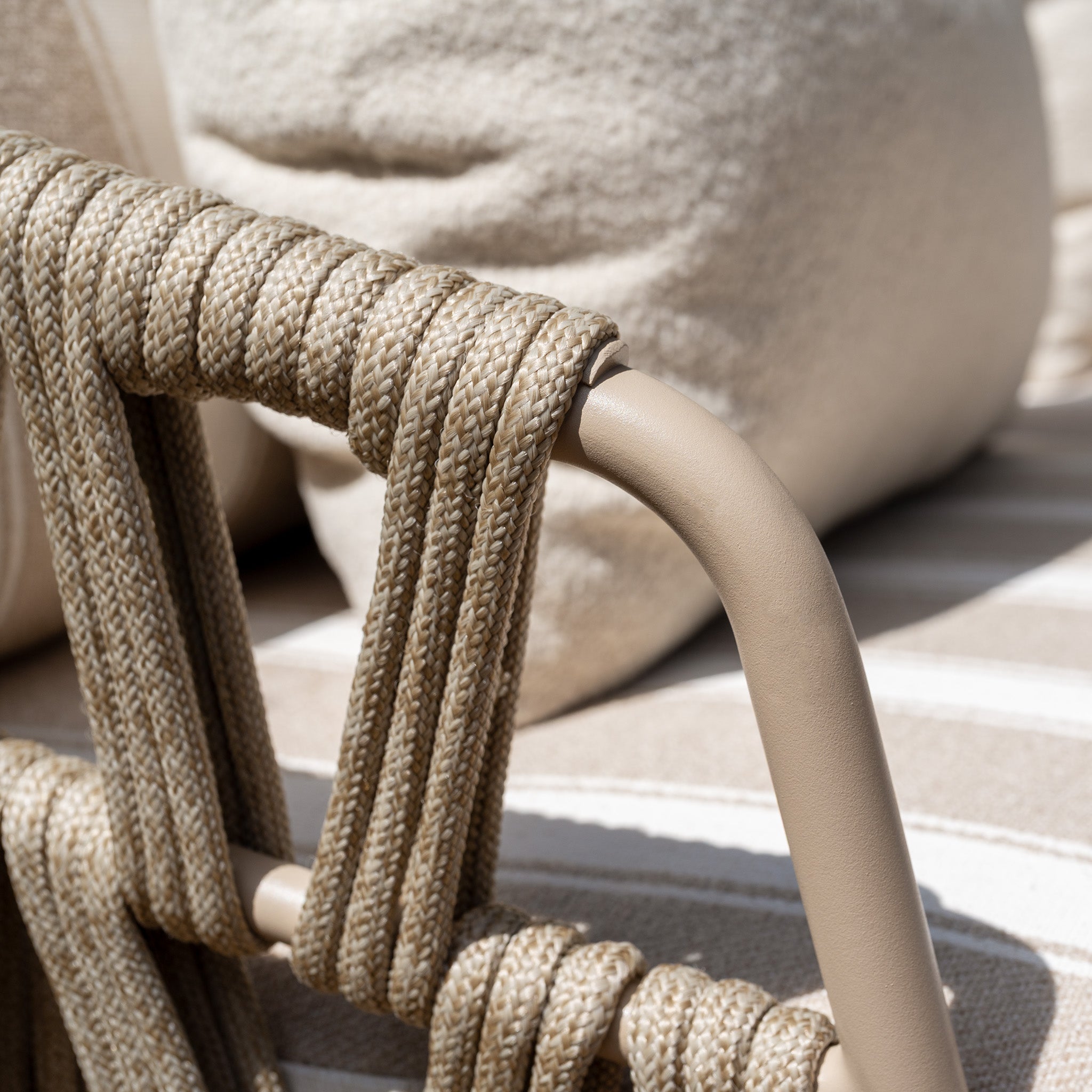 Close-up of the Madeira 6 Seat Curved Rectangular Dining Set in Striped Latte, featuring a beige woven chair backrest, soft neutral cushions, and a powder-coated aluminium table—perfect for any outdoor dining space.