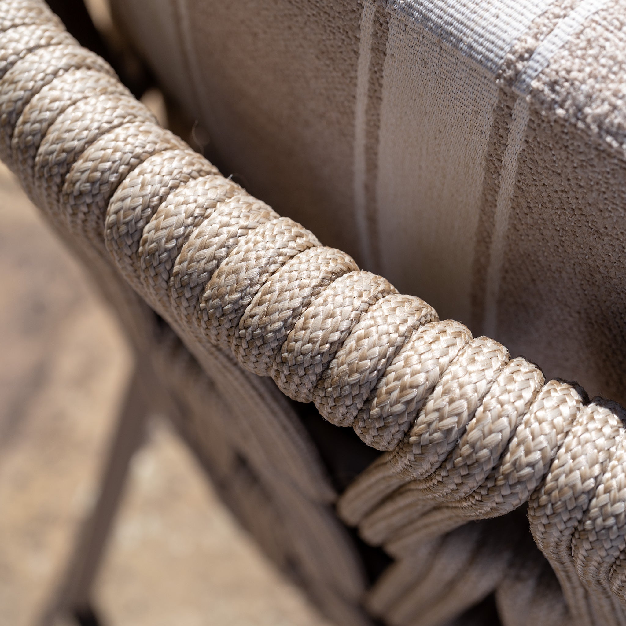 Close-up of the beige woven rope on the Madeira 6 Seat Curved Rectangular Dining Set in Striped Latte, wrapped around the chair frame and paired with a striped fabric backrest for a stylish modern garden dining look.