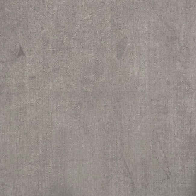 A close-up of a textured gray concrete wall surface evokes the elegance of the Chesterfield Velvet Footstool in Mink.