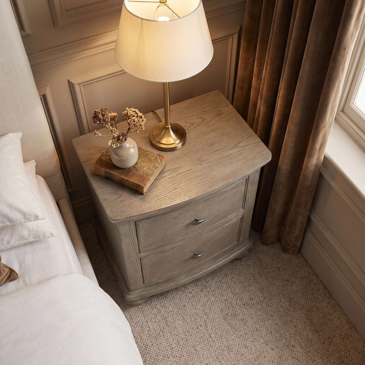 a lamp on a table next to a bed