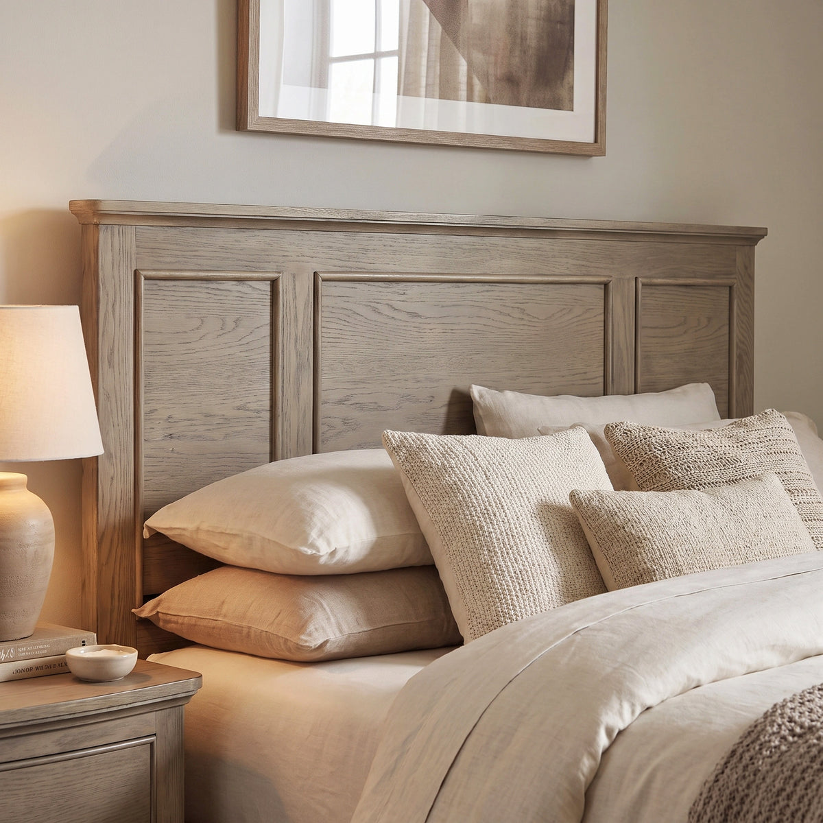 a bed with pillows and a lamp on a nightstand