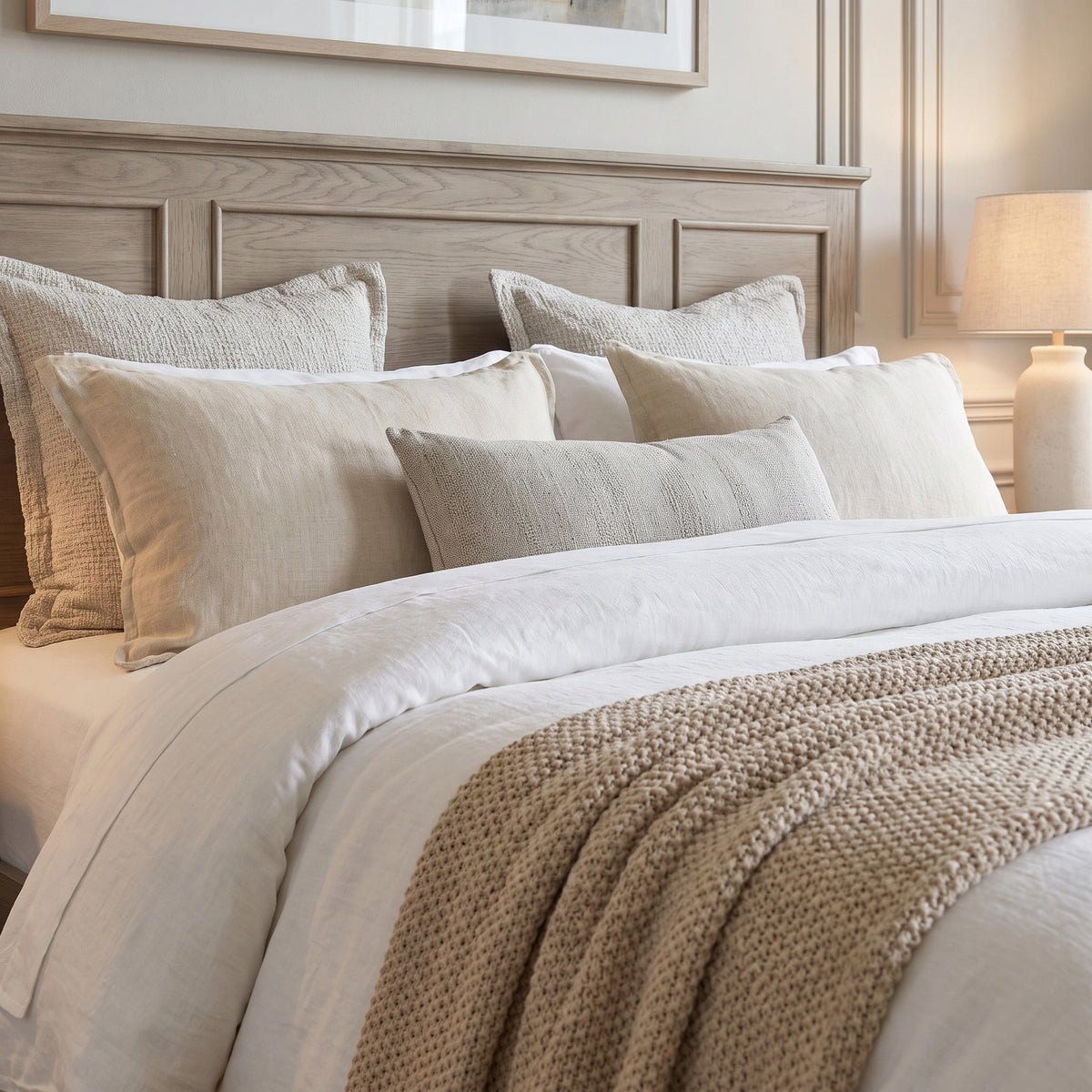 a bed with pillows and a lamp