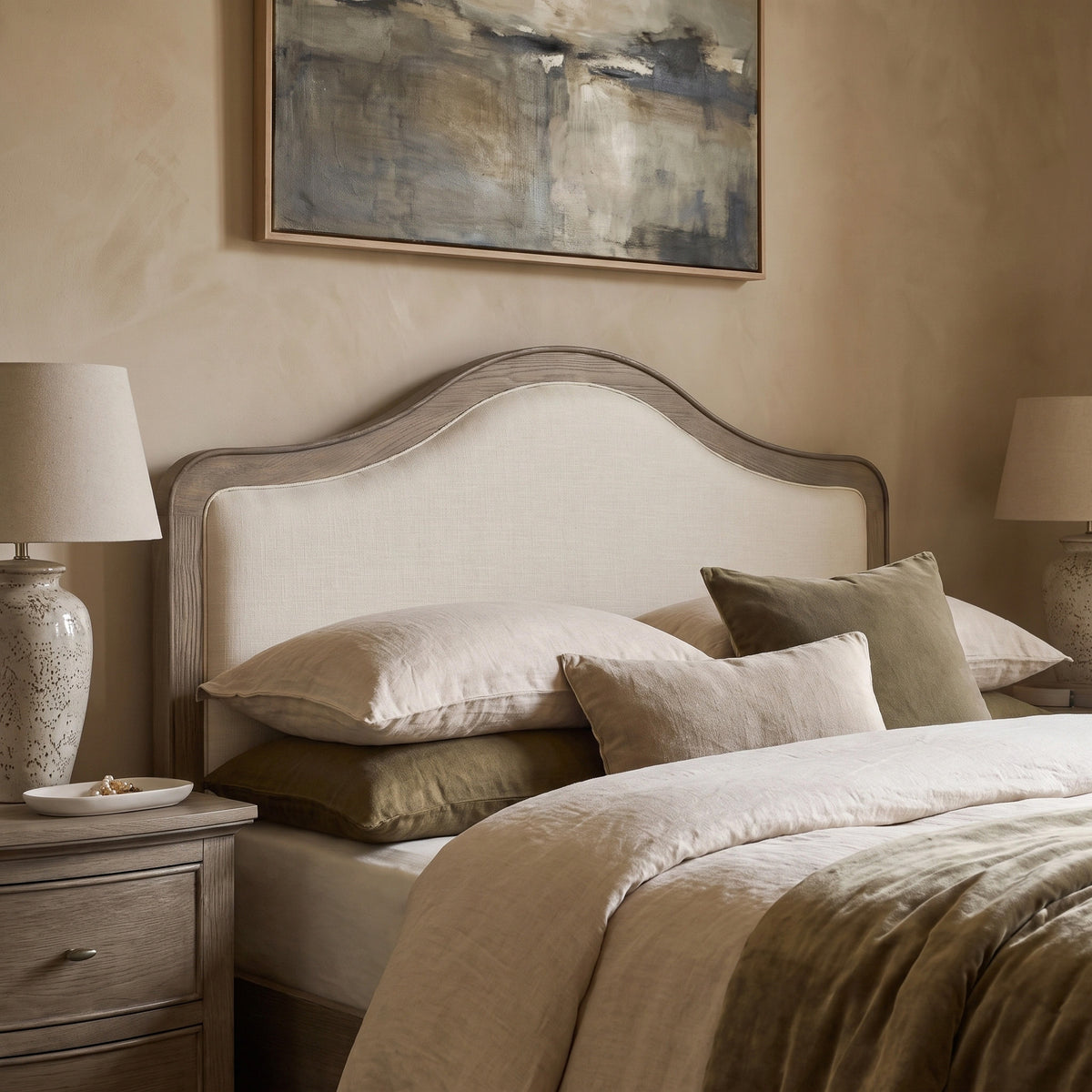 a bed with a painting above it