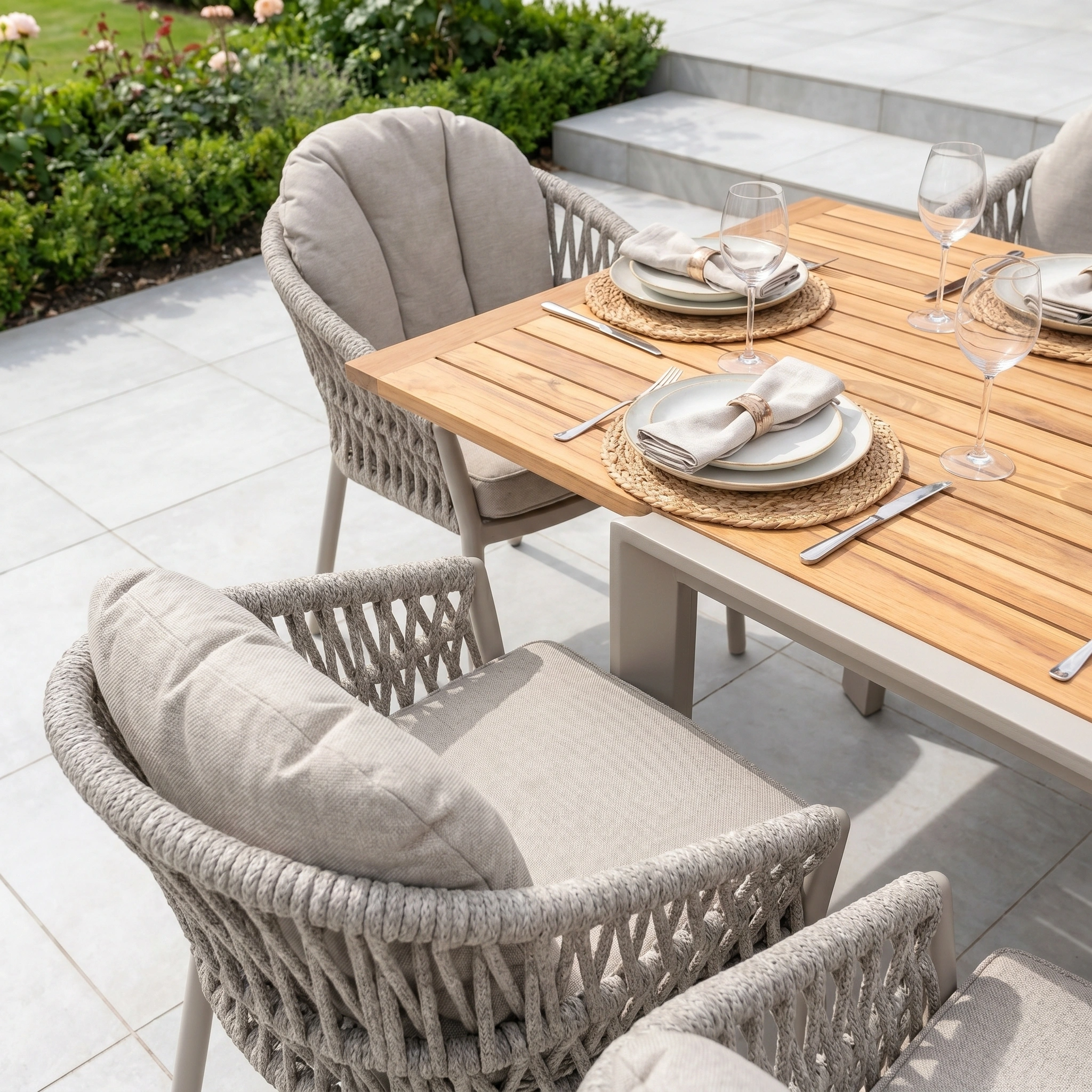 The Pello 10 Seat Extending Dining Set features a teak table in fawn and cushioned chairs, perfect for stylish outdoor dining on your patio.