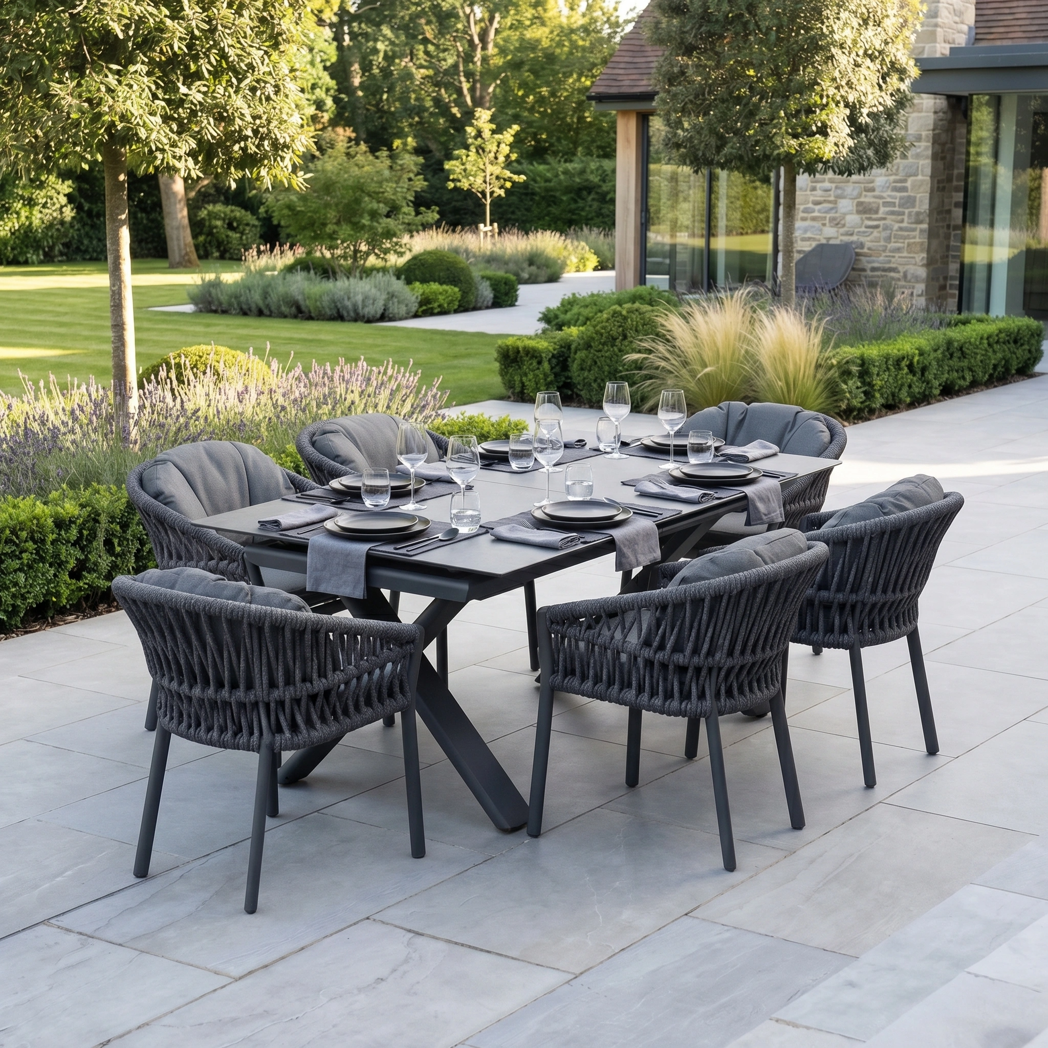 The Pello 6 Seat Dining Set with Albatross Extending Table in Grey features stylish woven chairs and a sleek table, ideal for elegant outdoor dining in any garden setting.