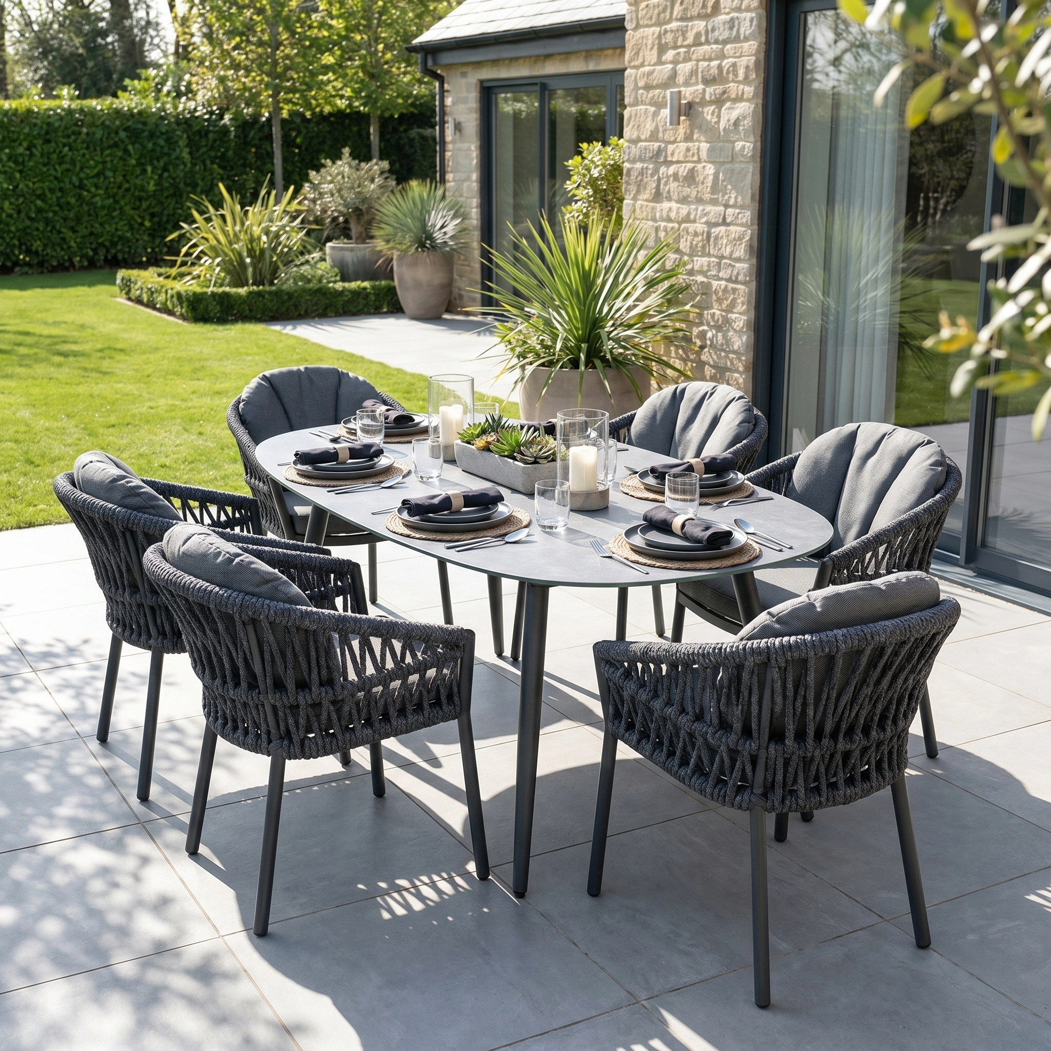 The Pello 6 Seat Oval Dining Set with Ceramic Table in Grey features cushioned chairs around a sleek table—stylish grey garden patio furniture, perfect for outdoor dining.