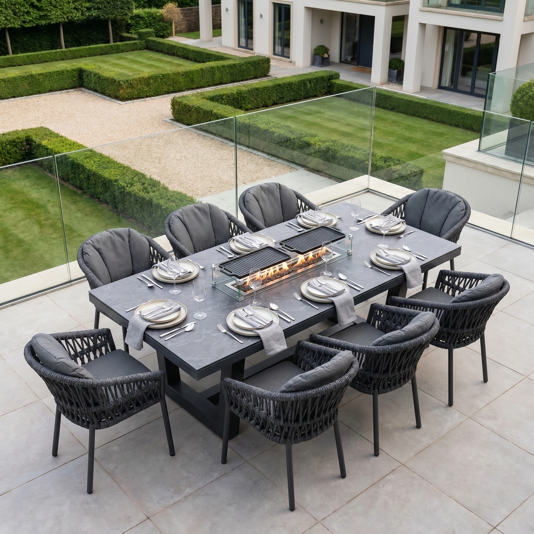 The Pello 8 Seat Rectangular Ceramic Firepit Dining Set in Grey features eight chairs and a ceramic firepit table, creating weather-resistant patio dining perfect for stylish and cozy outdoor gatherings.