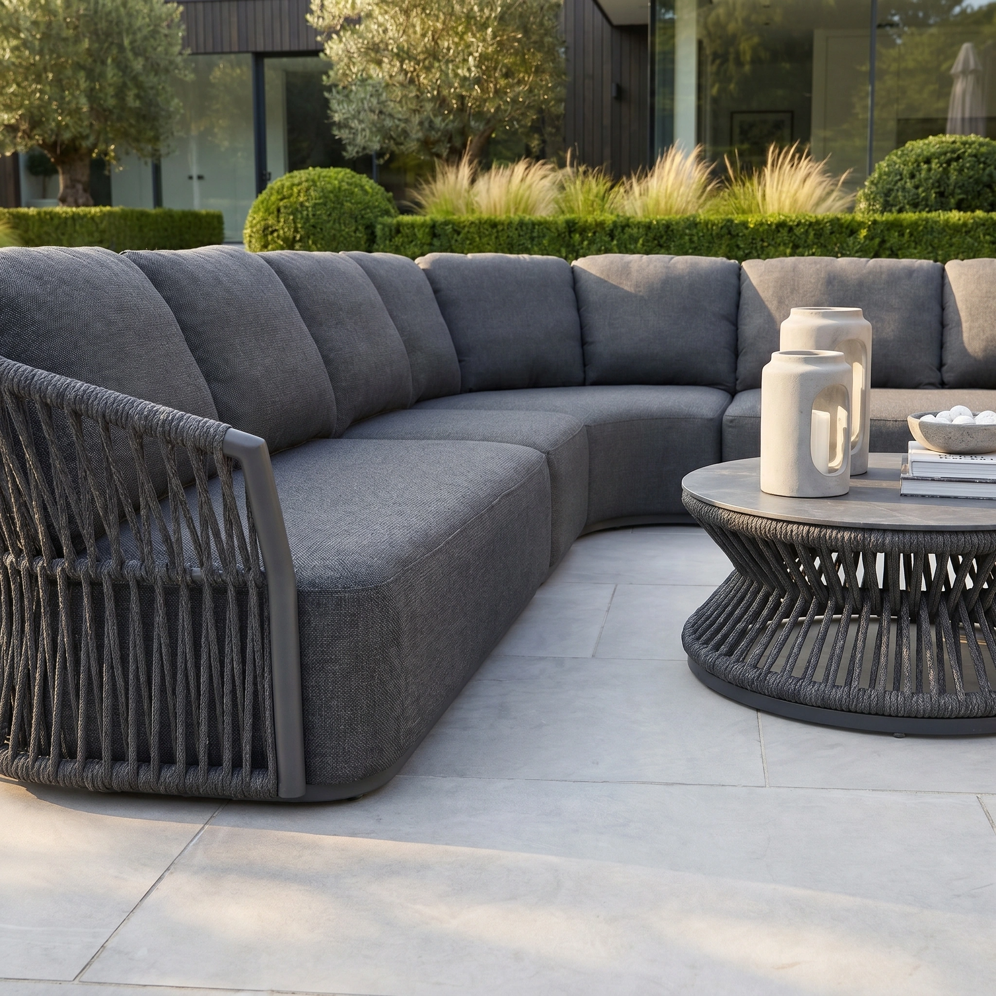The Pello Deluxe Curved Sofa Set with Round Coffee Table in Grey offers weather-resistant, stylish outdoor seating for your patio or garden, blending luxury and comfort with a modern curved design.