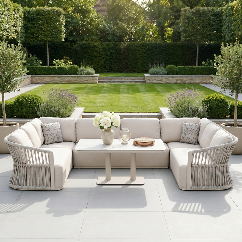 Outdoor patio with the Pello U-Shape Corner Sofa Set in fawn and Altura Rising Table, plus a vase of flowers, overlooking a landscaped garden.